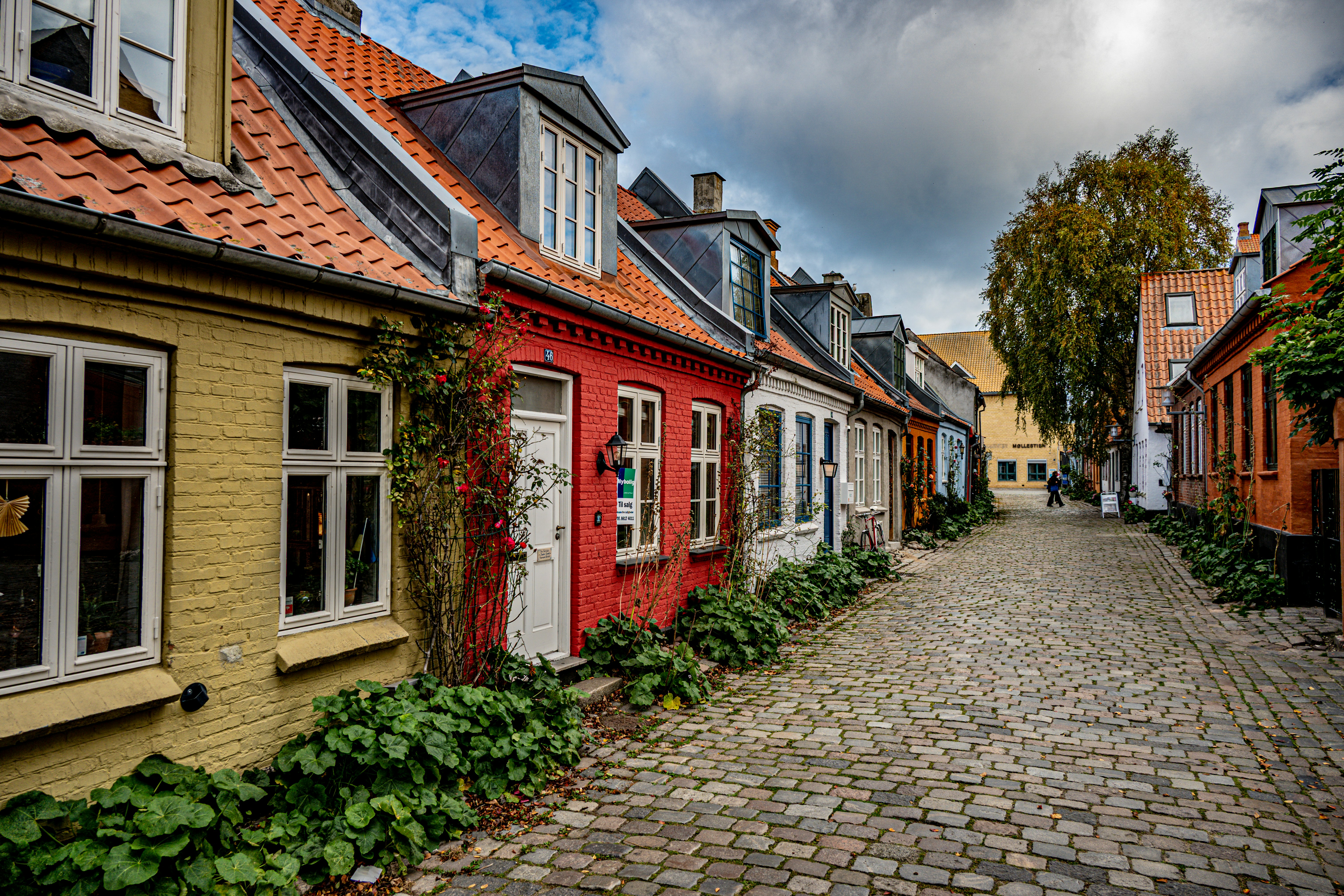 Colorful row houses line a cobblestone street.