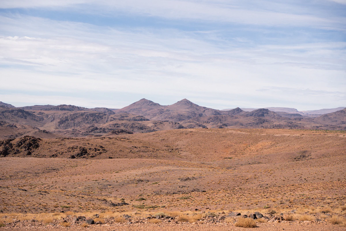 A stony desert plain below bare rocky hills in Morocco