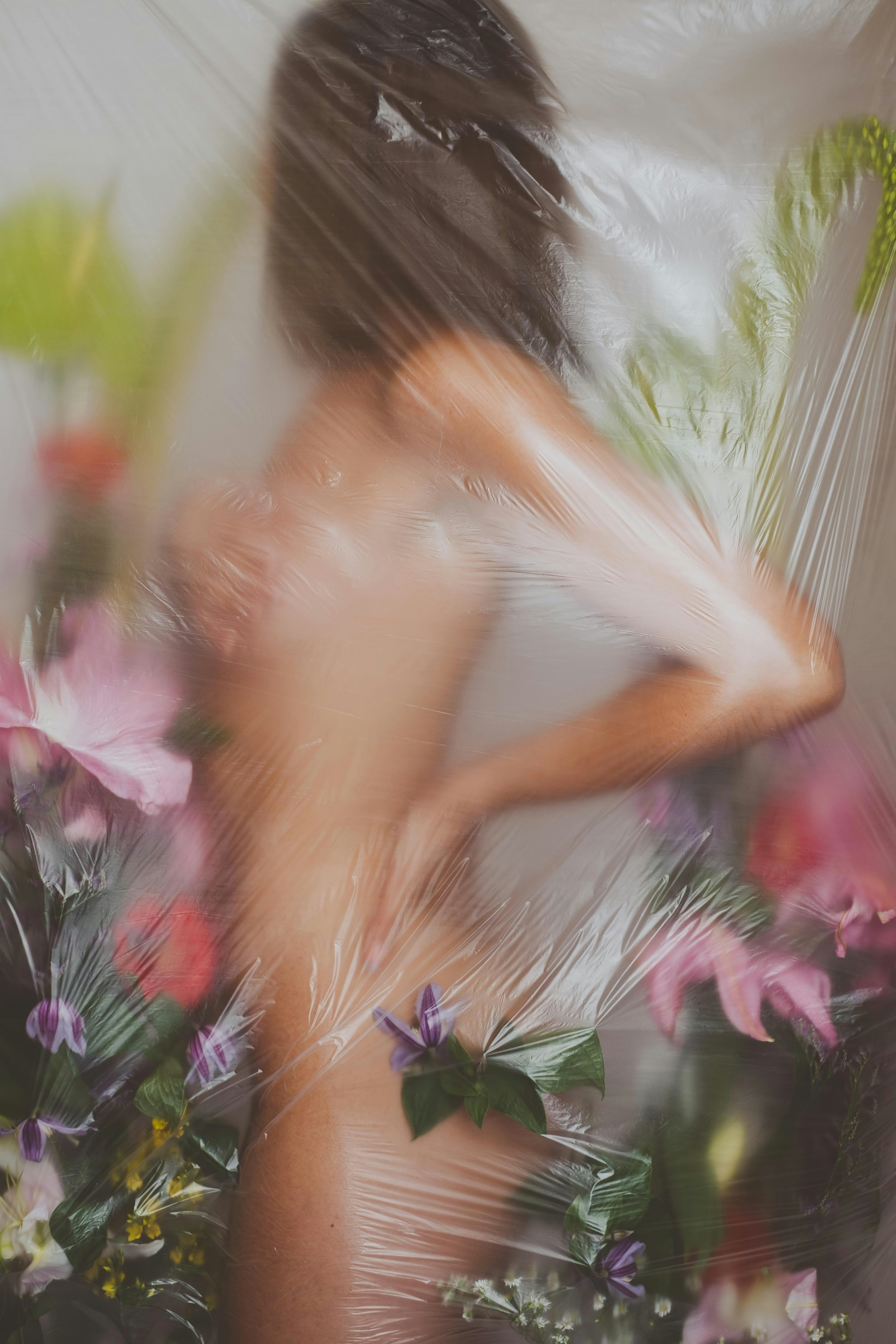 Woman covered in plastic wrap with flowers