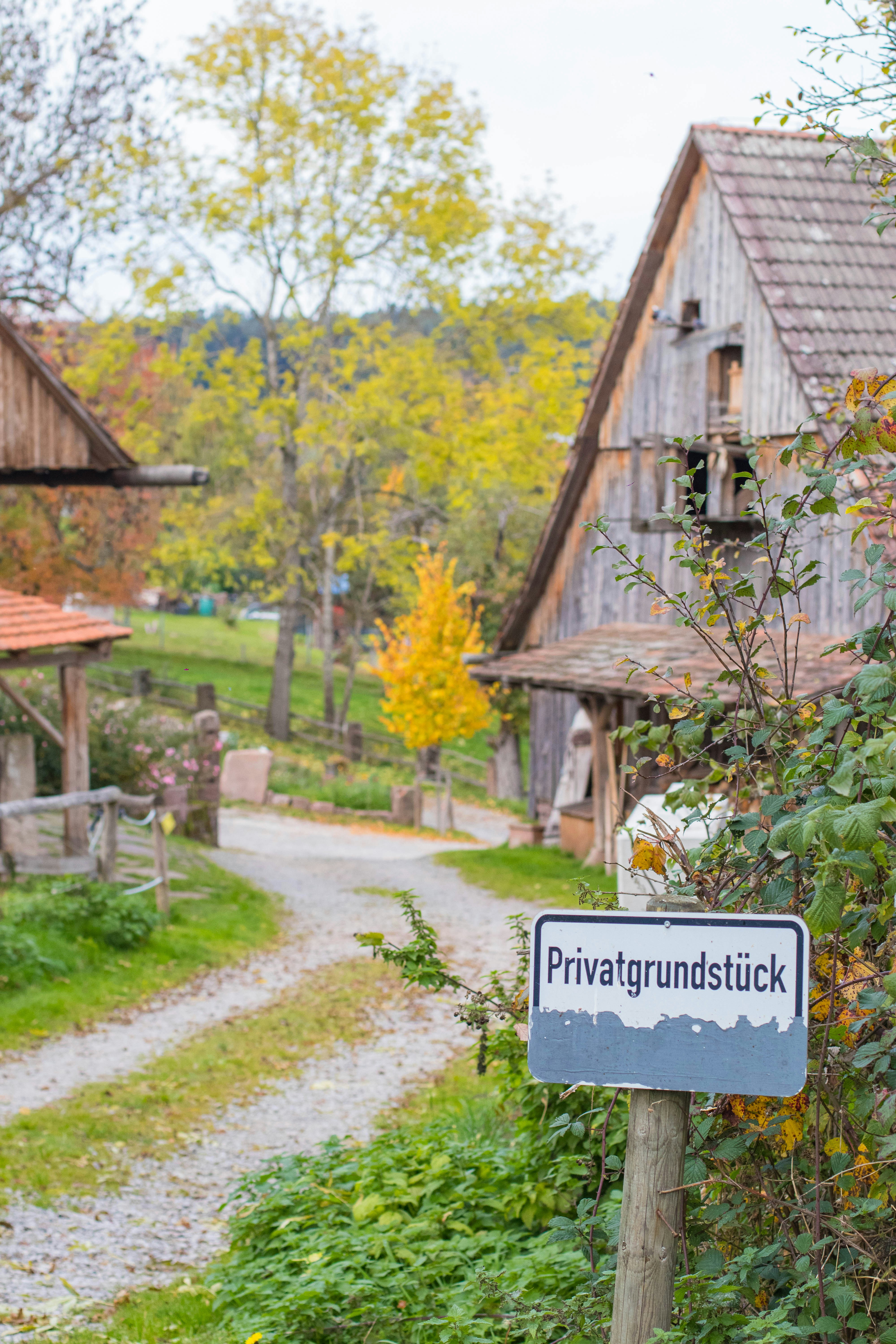 Privatgrundstücksschild vor rustikalen Holzbauten
