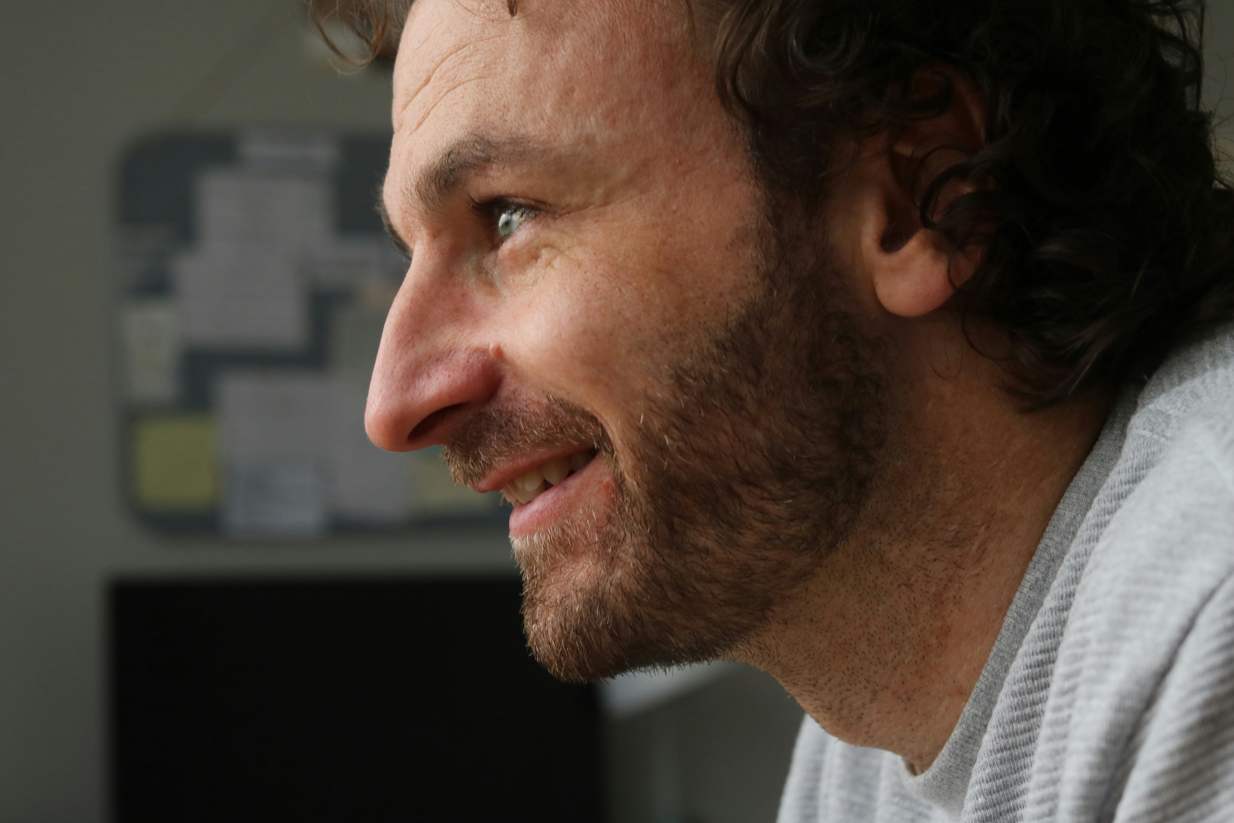 Hombre con barba sonriendo mirando hacia un lado