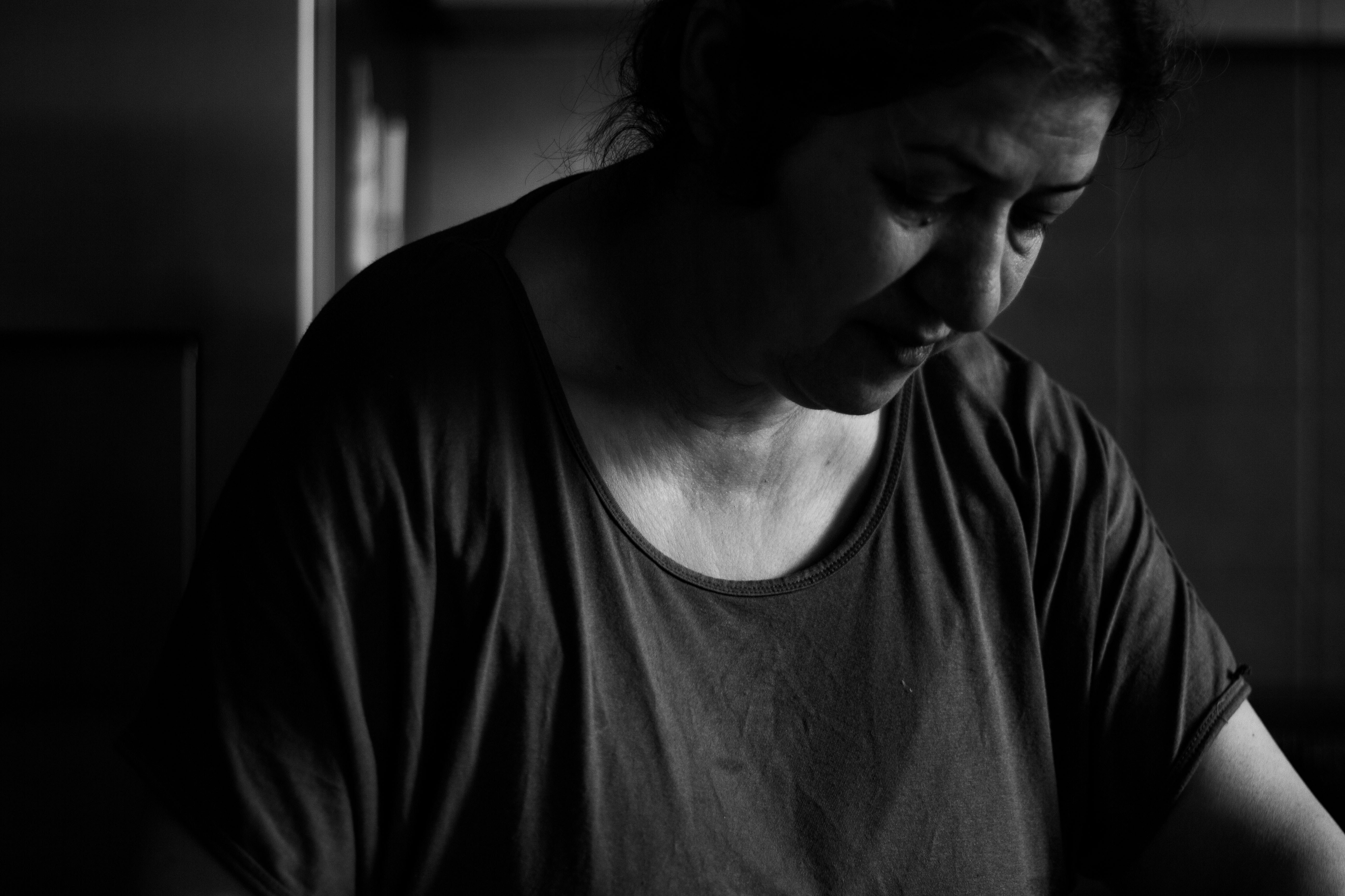 A woman looking down in black and white.