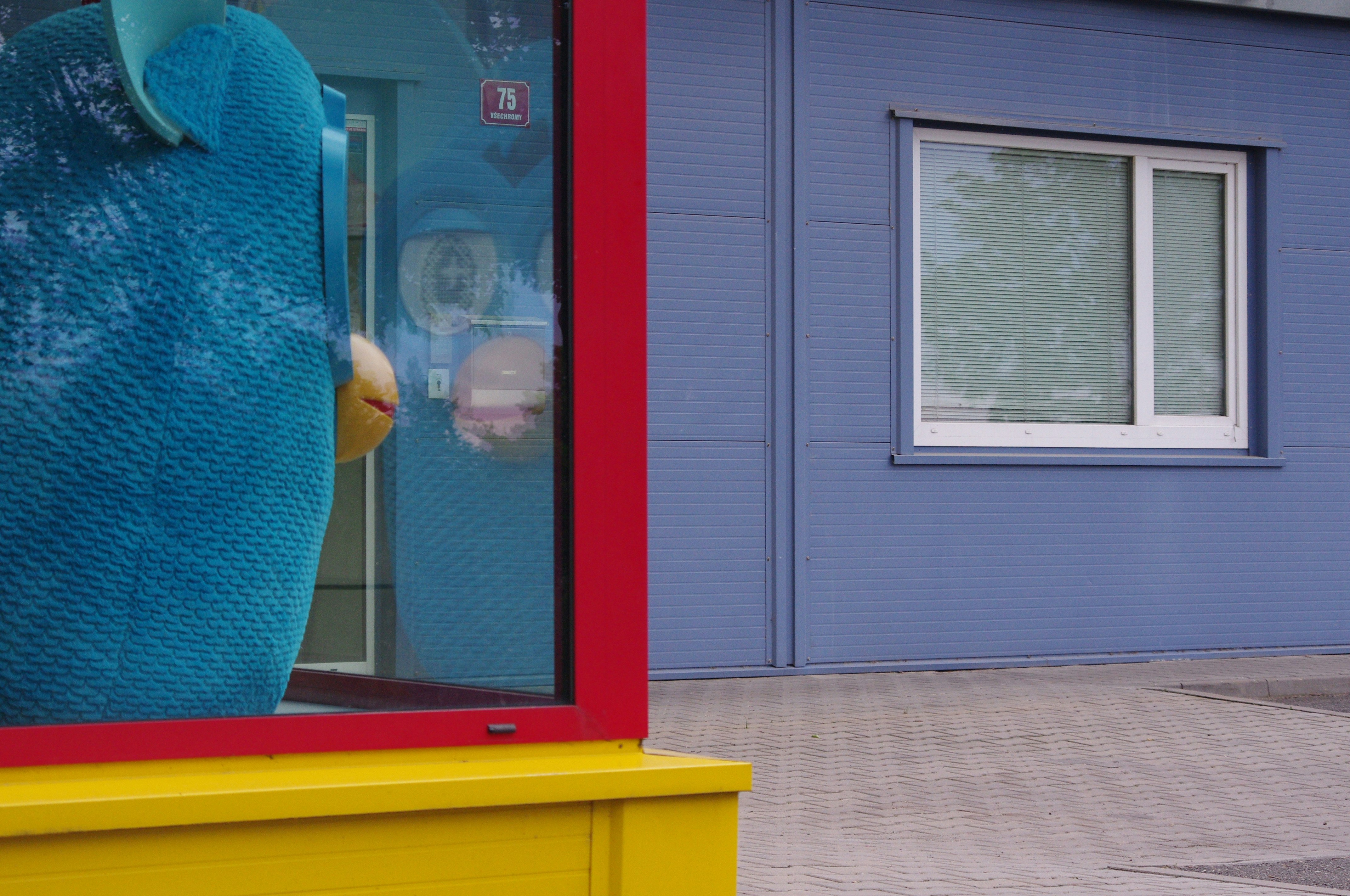 Blue character behind a red and yellow frame