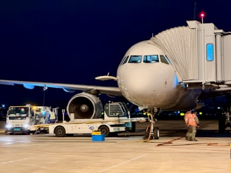 Airplane connected to a jet bridge at night