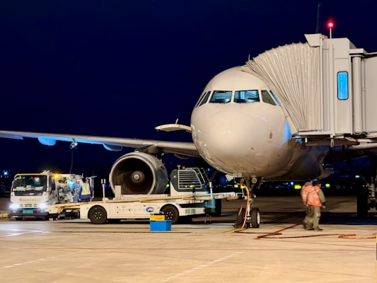 Airplane connected to a jet bridge at night