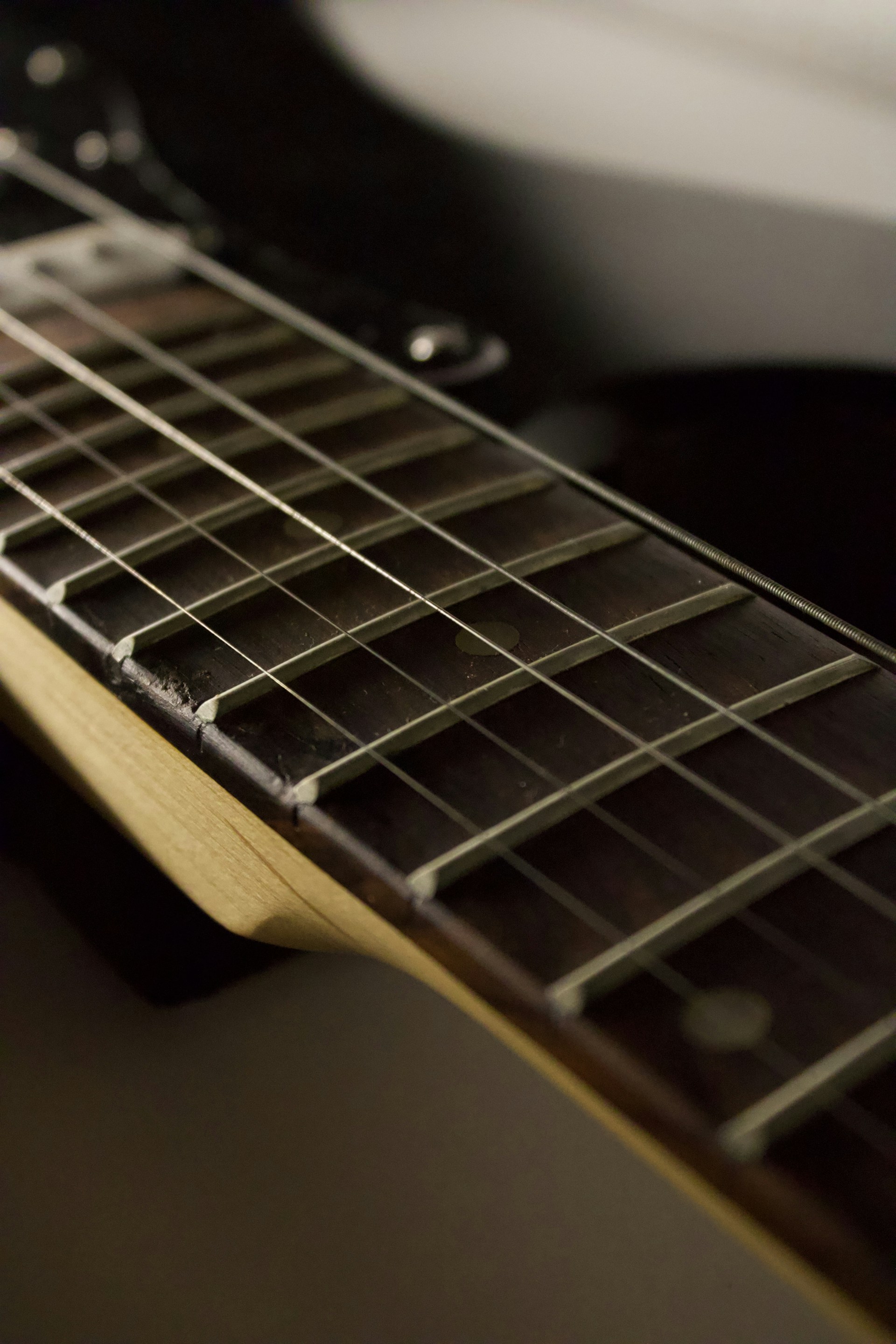 Close-up of electric guitar strings and fretboard.
