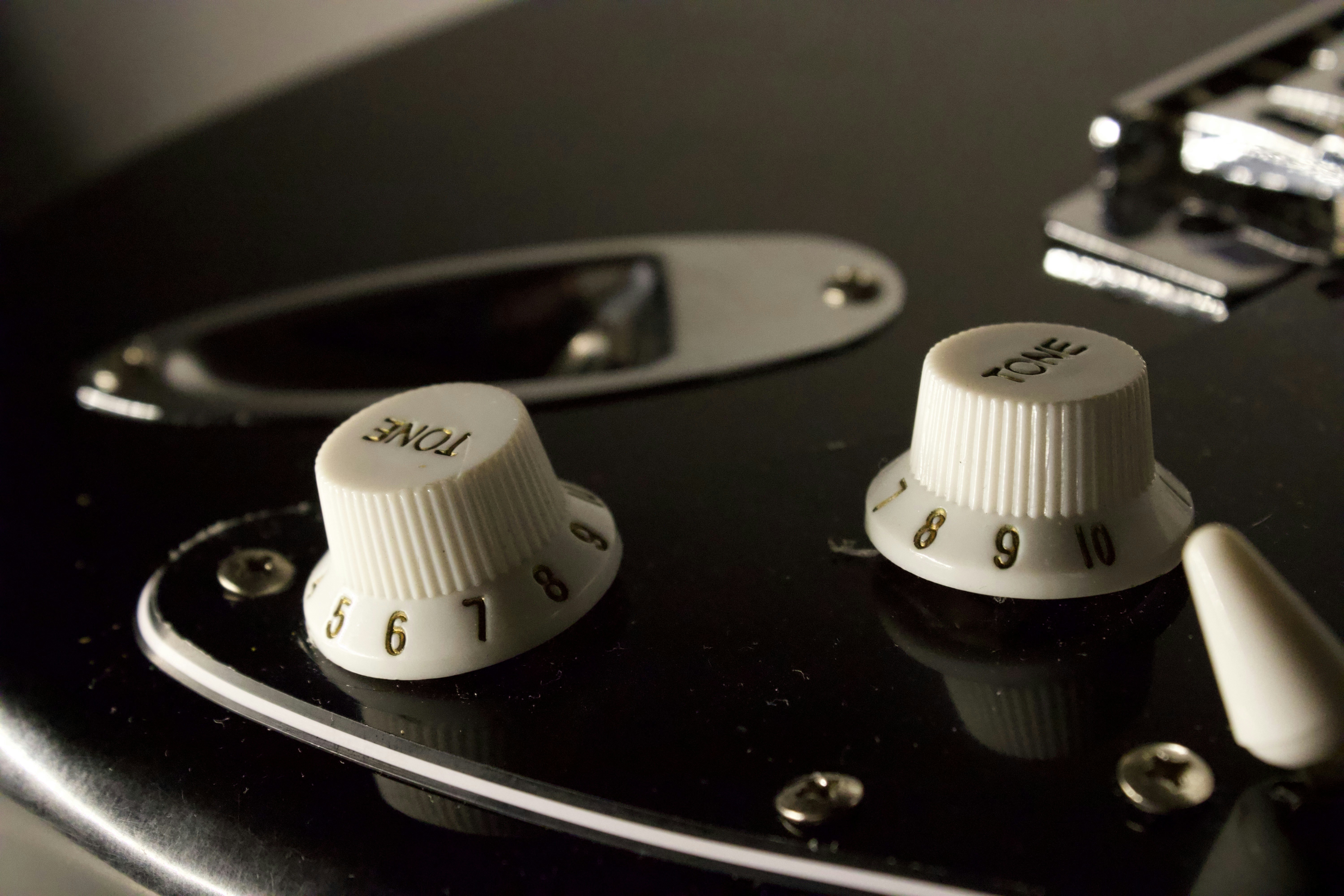Nahaufnahme von zwei weißen Gitarren-Bedienknöpfen