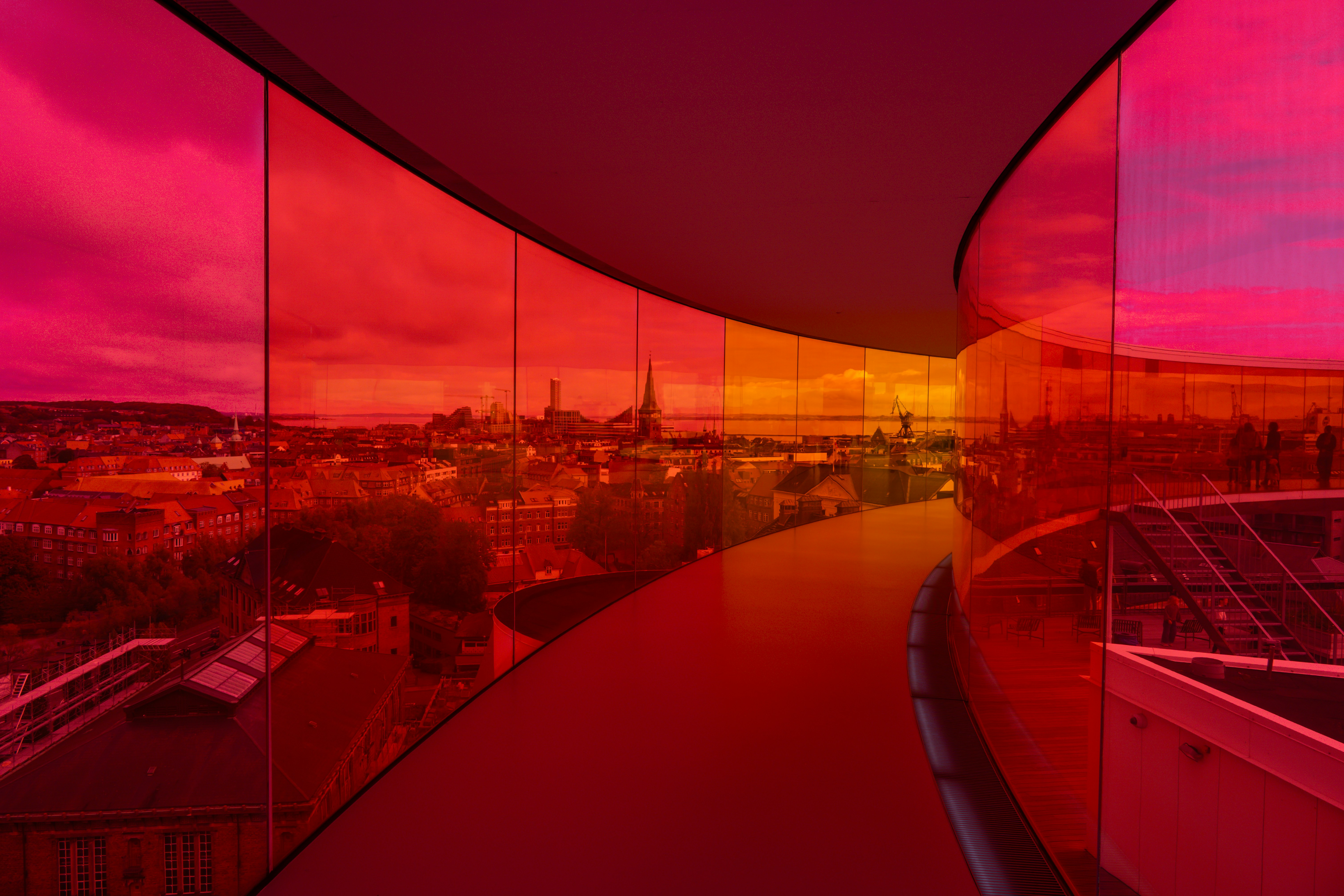 Modern architecture with colorful glass overlooking cityscape.