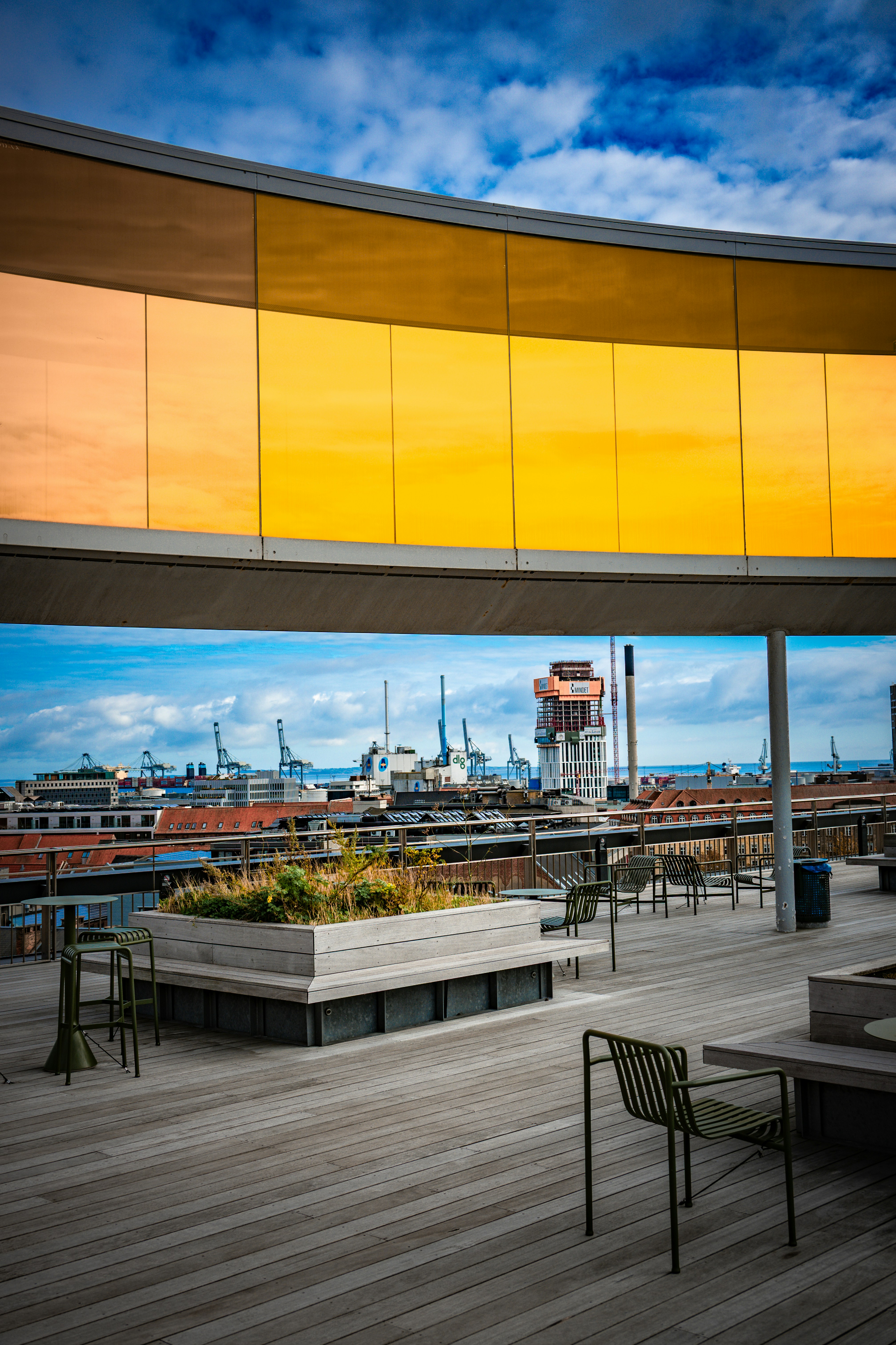 Rooftop view of a city with industrial cranes and buildings.