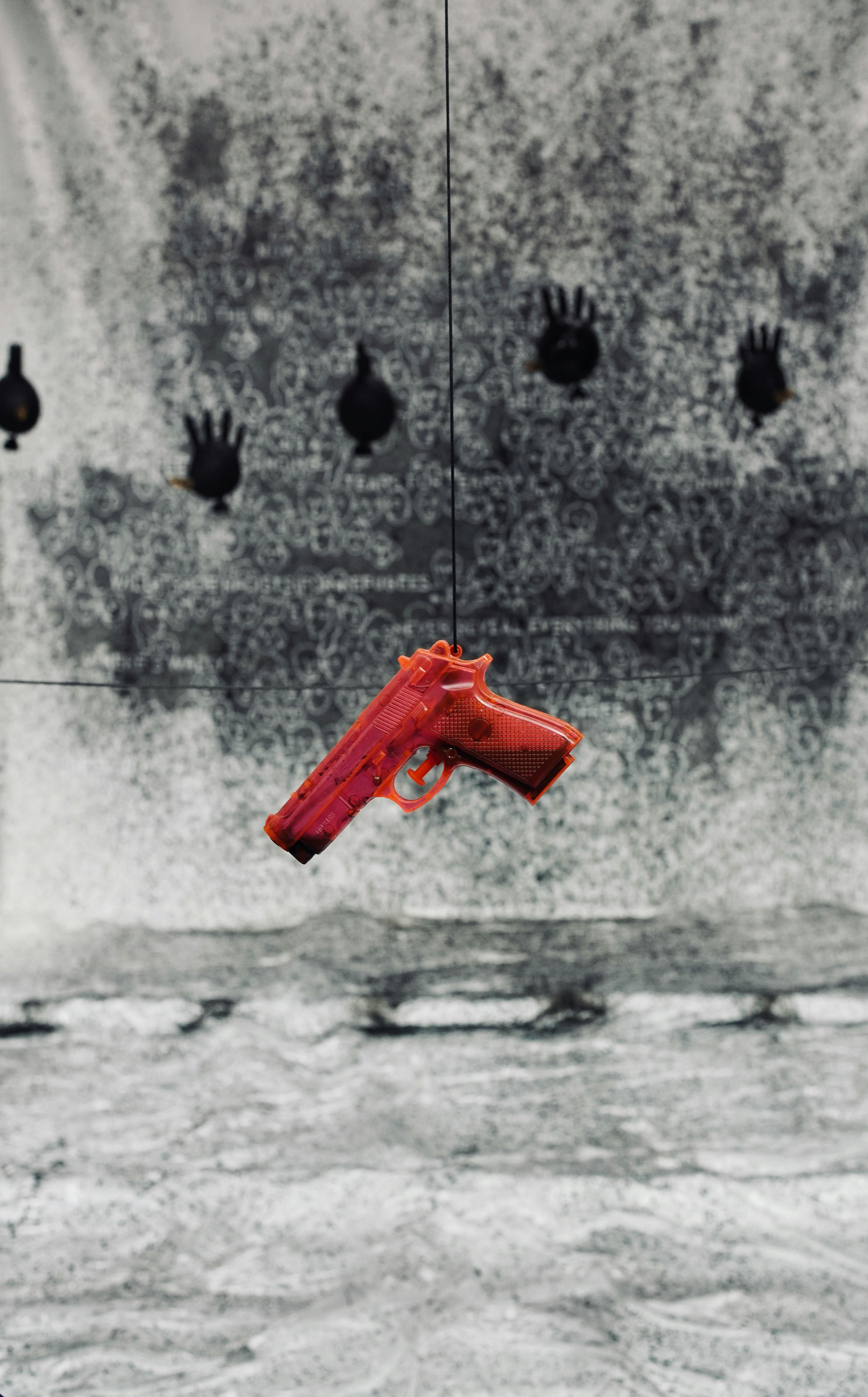 A red plastic gun hanging in front of a target.