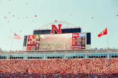Fans and student section celebrating in a packed football stadium