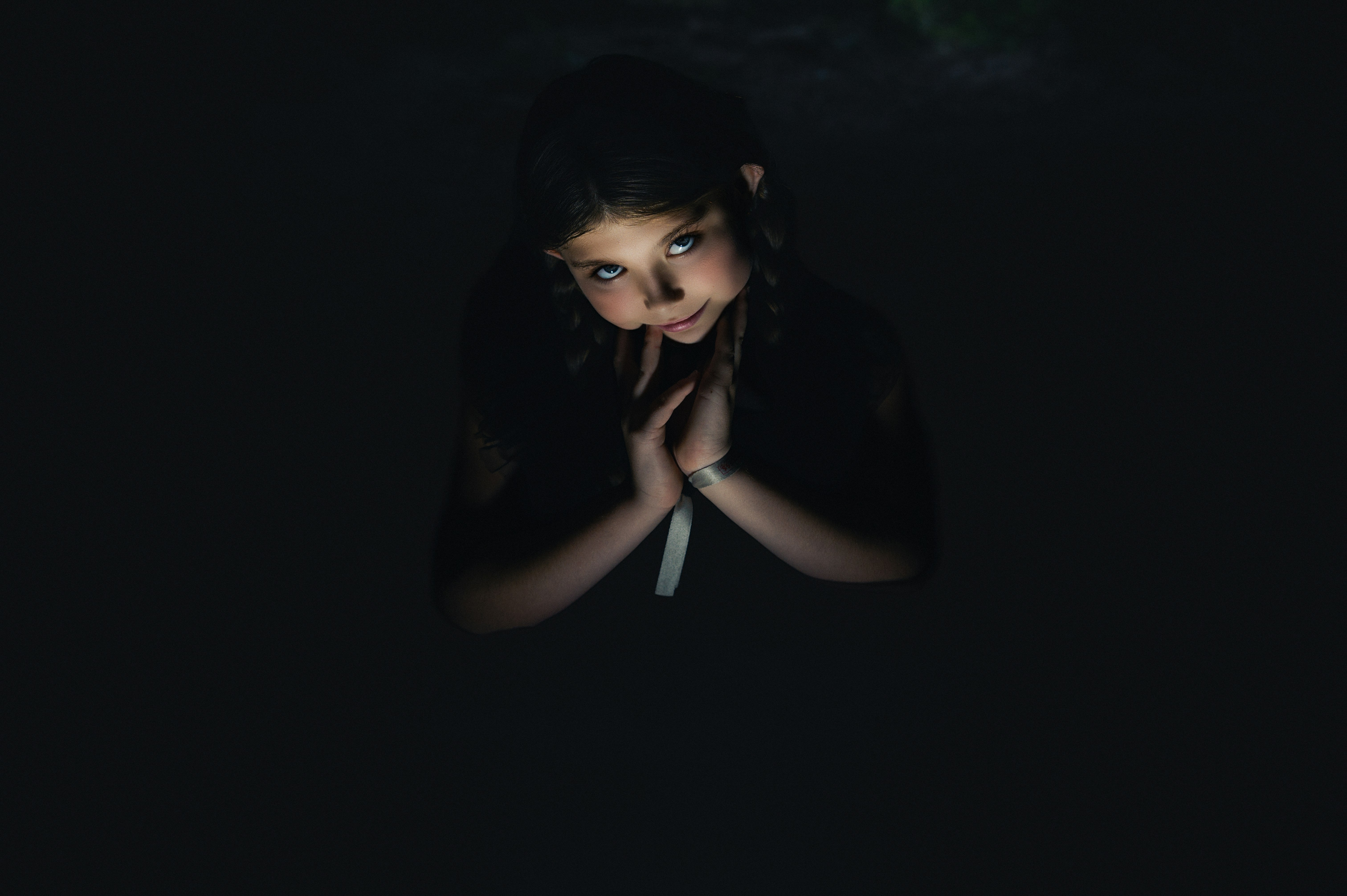 Young girl looking up with hands clasped