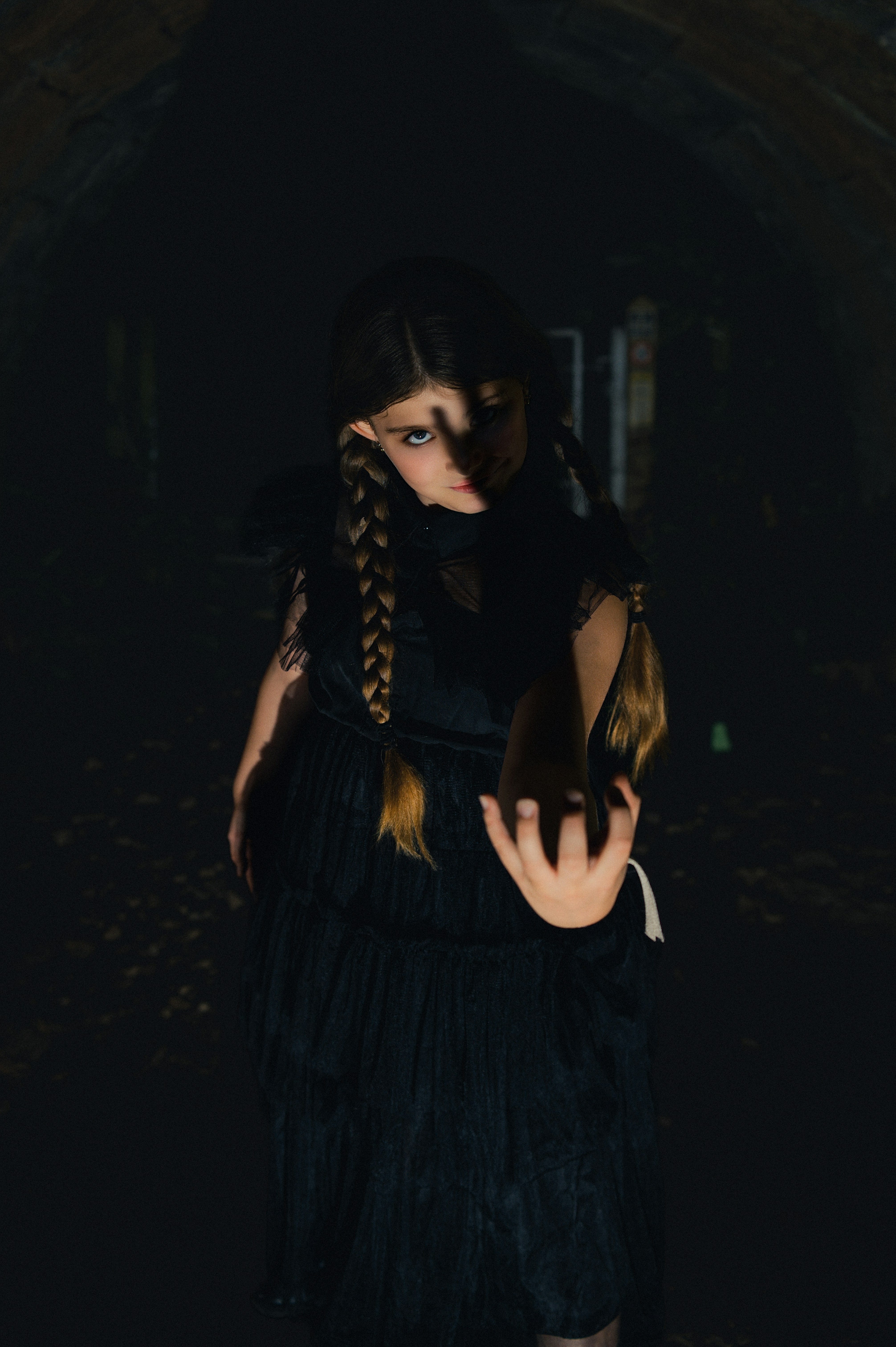 A young girl with braids in a dark setting