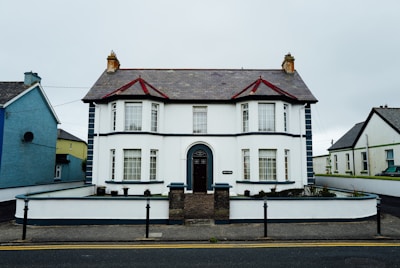 A white two-story house with a dark roof.