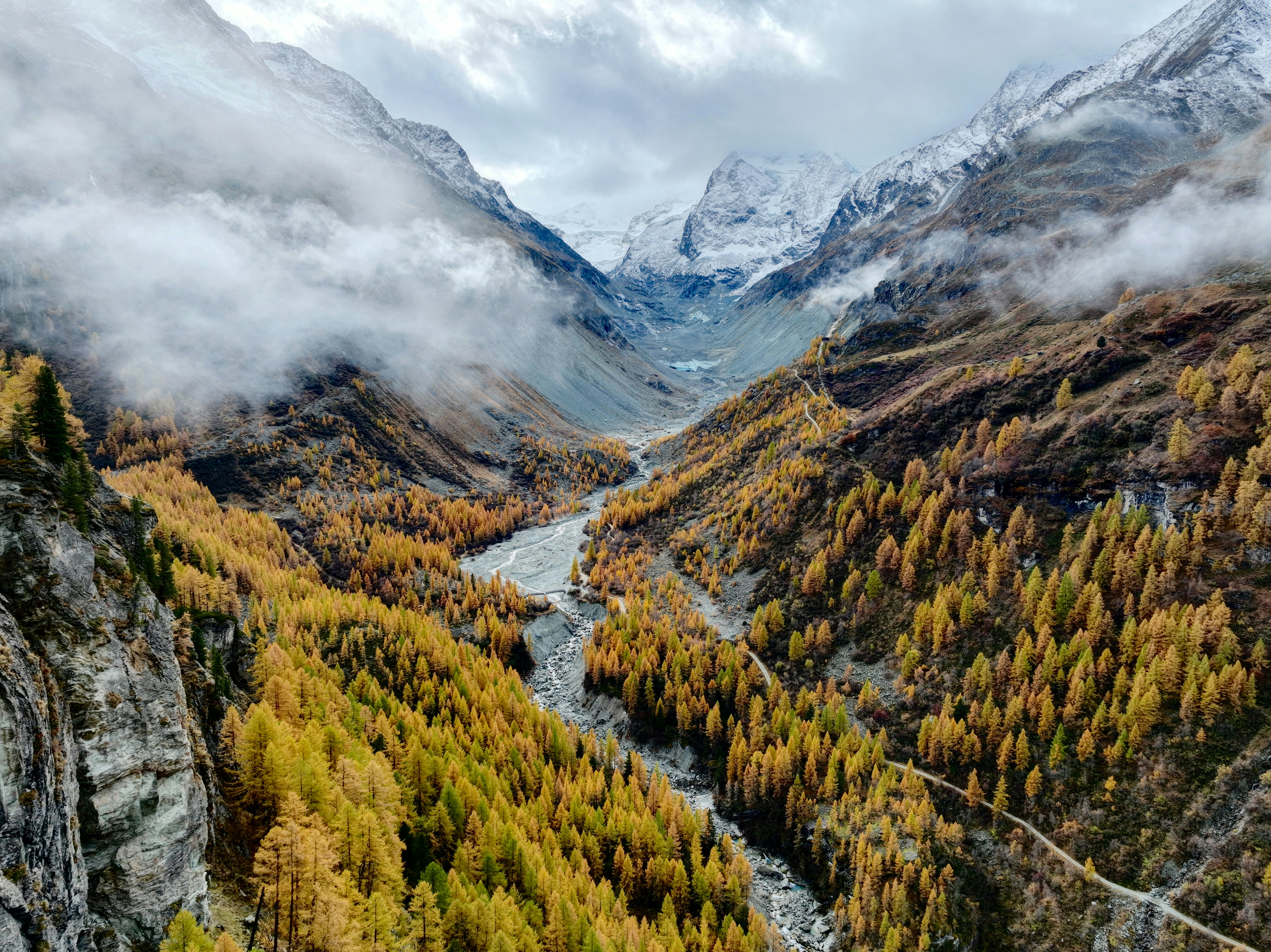 Autumn valley with river and misty mountains