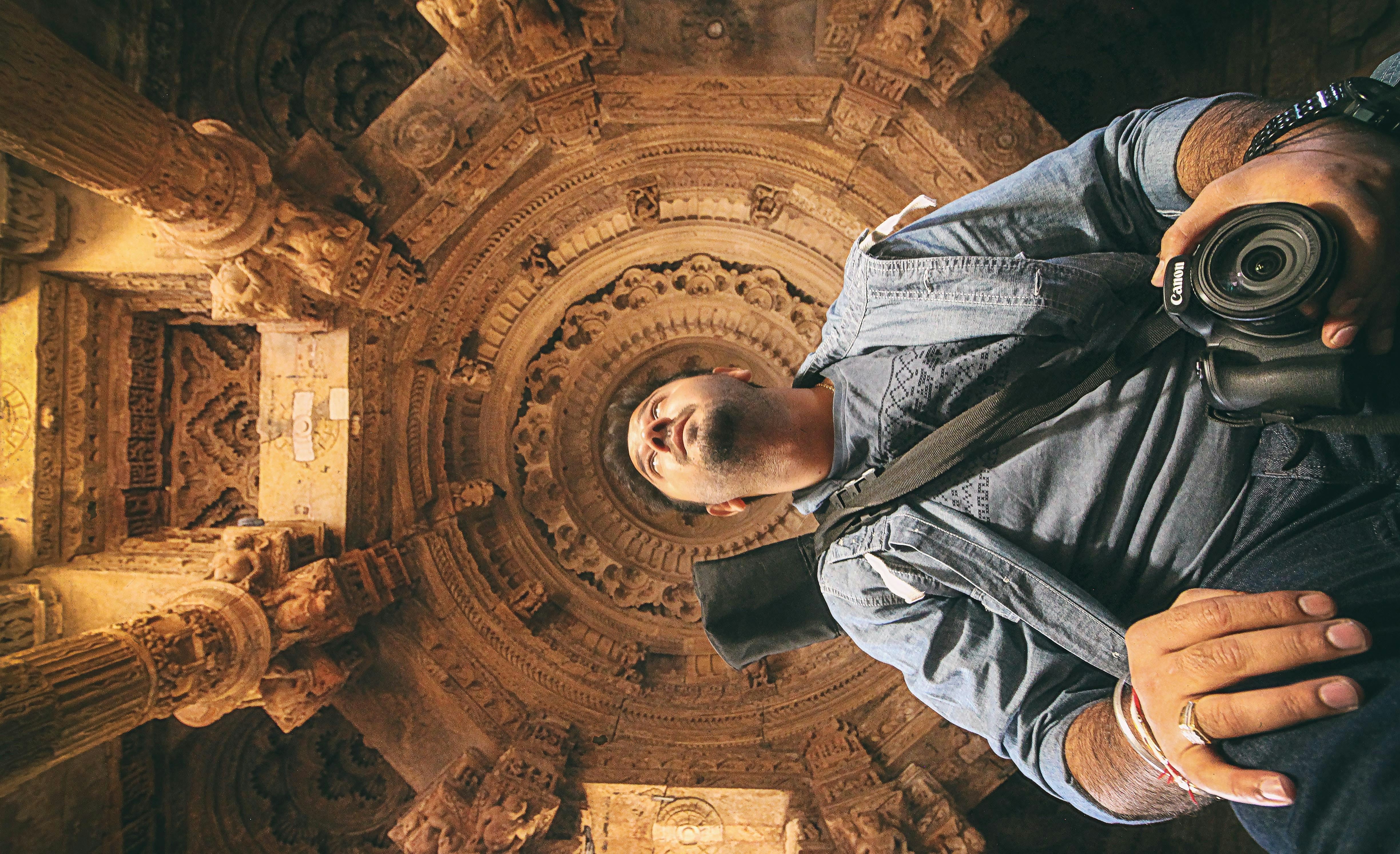 Man holding camera inside ornate ancient structure