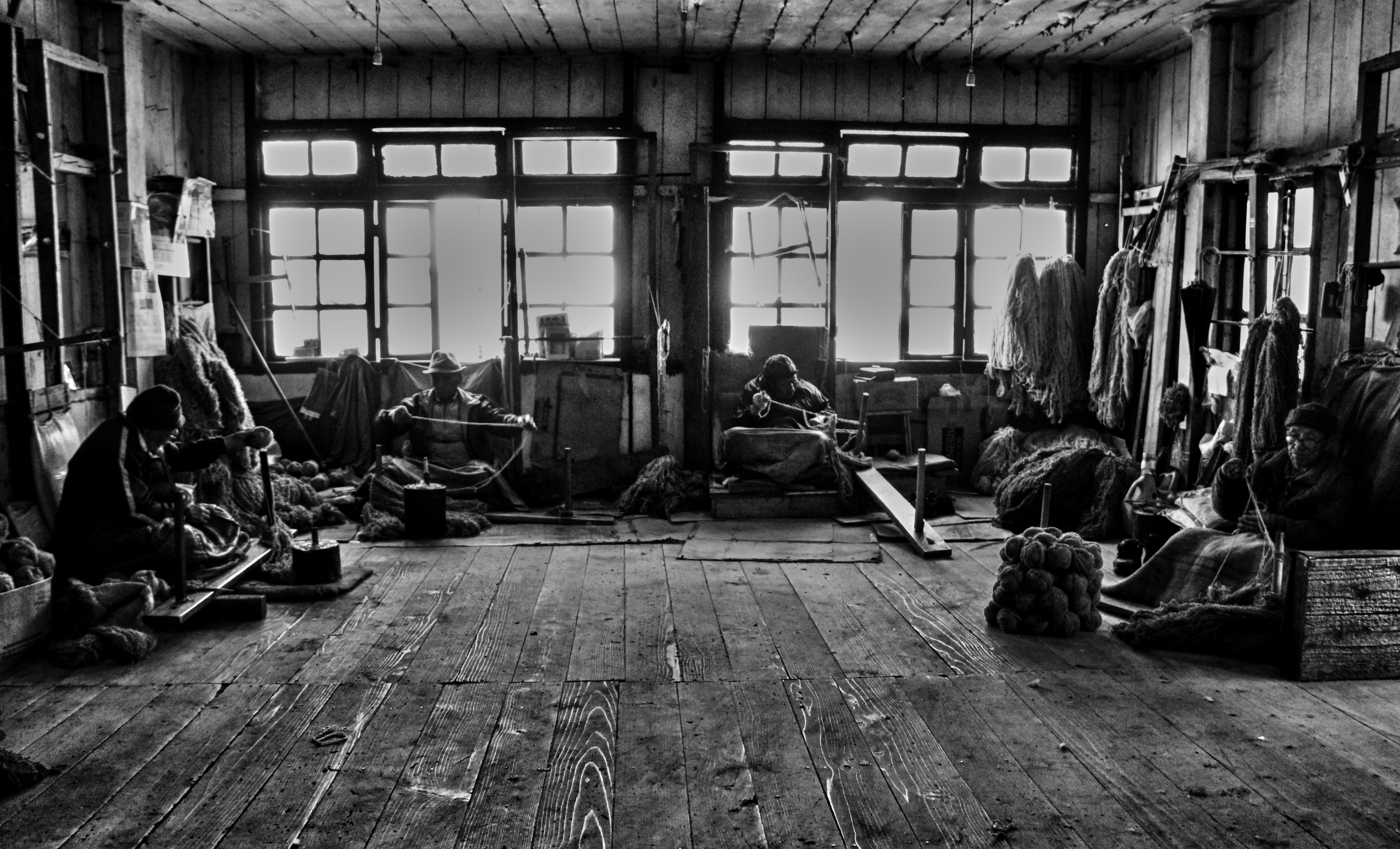 Old workshop with people working at tables.