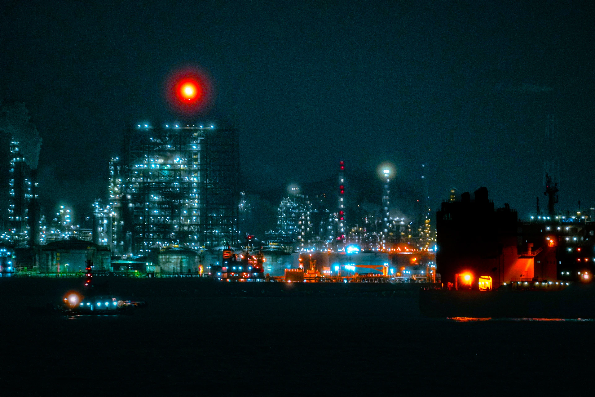 Industrial cityscape with glowing lights at night