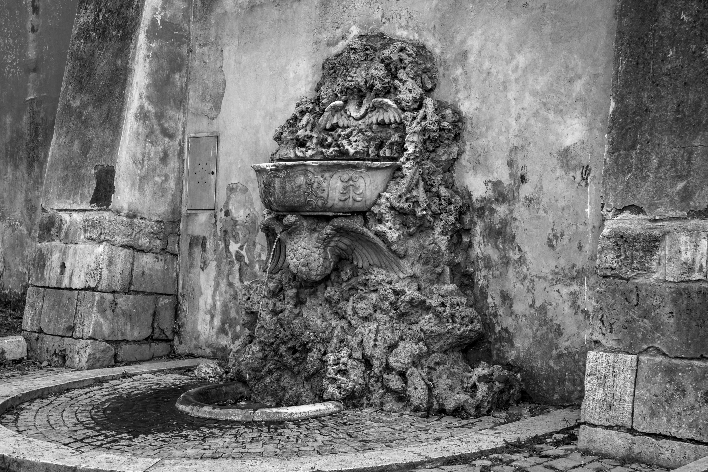 Ornate stone fountain with weathered walls