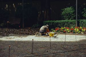 Gardener laying stones in a flower bed