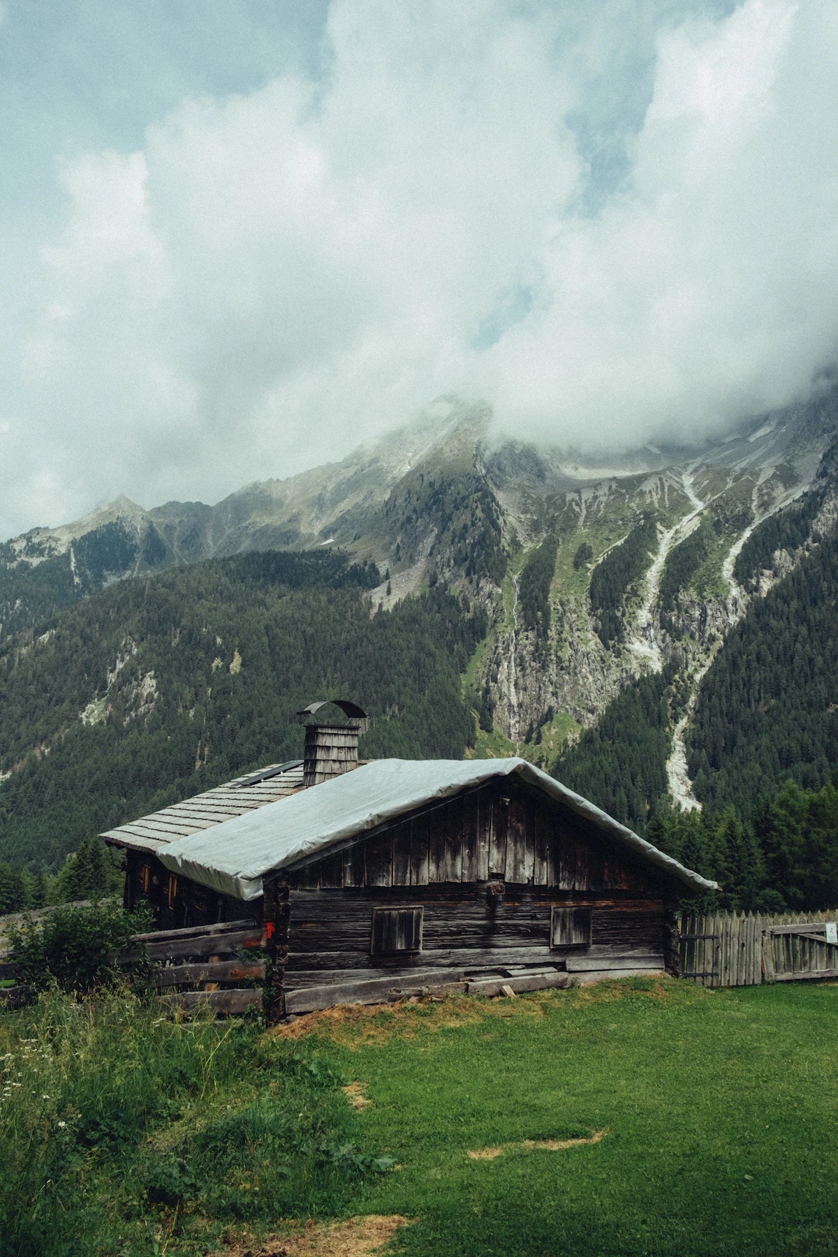 Cabaña de madera rústica en un paisaje verde de montaña