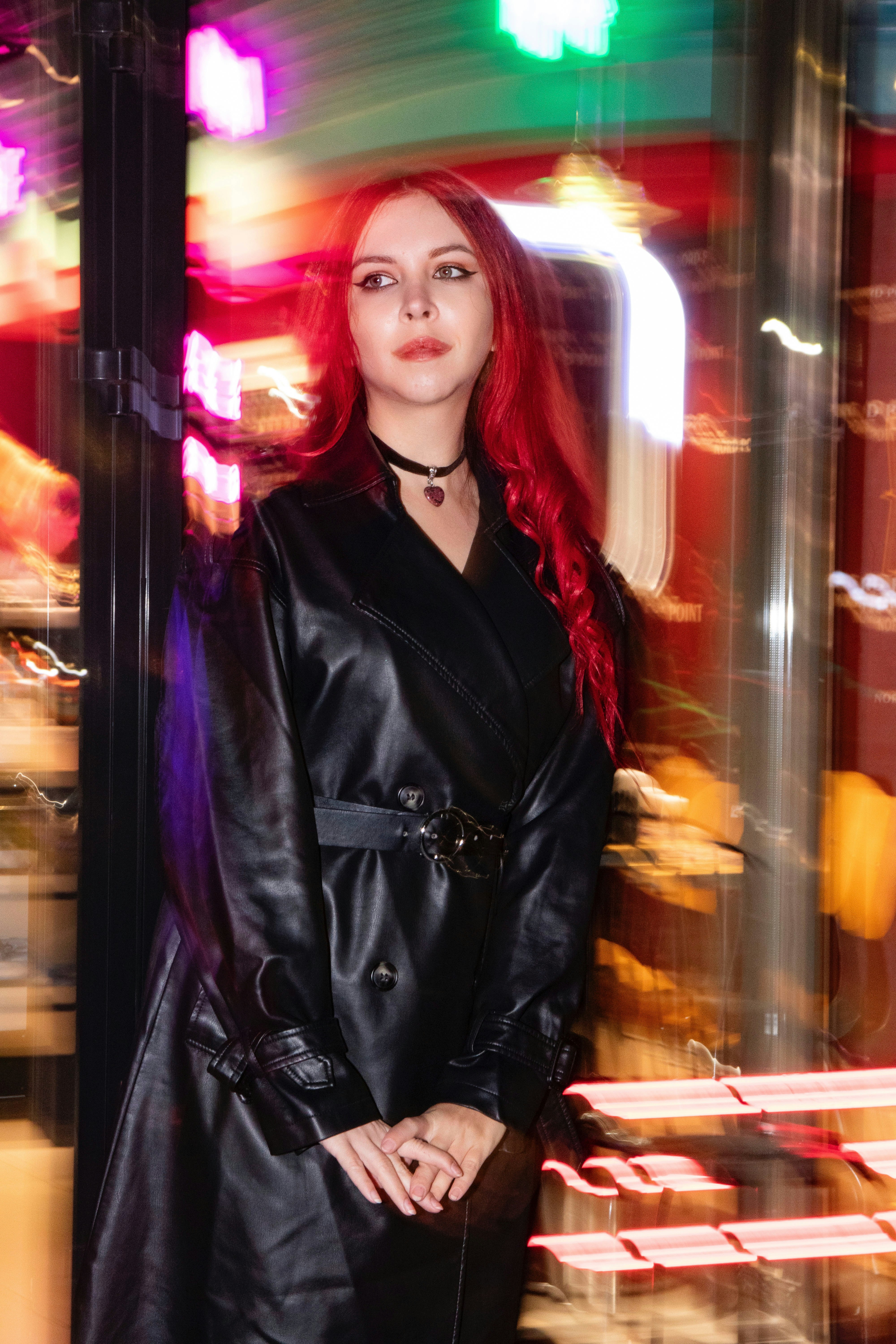Woman with red hair in a black coat at night