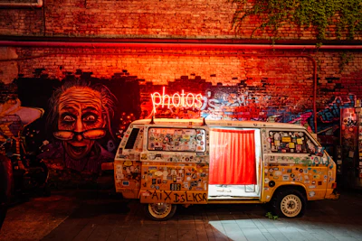 A vintage van with a neon 'photos' sign.