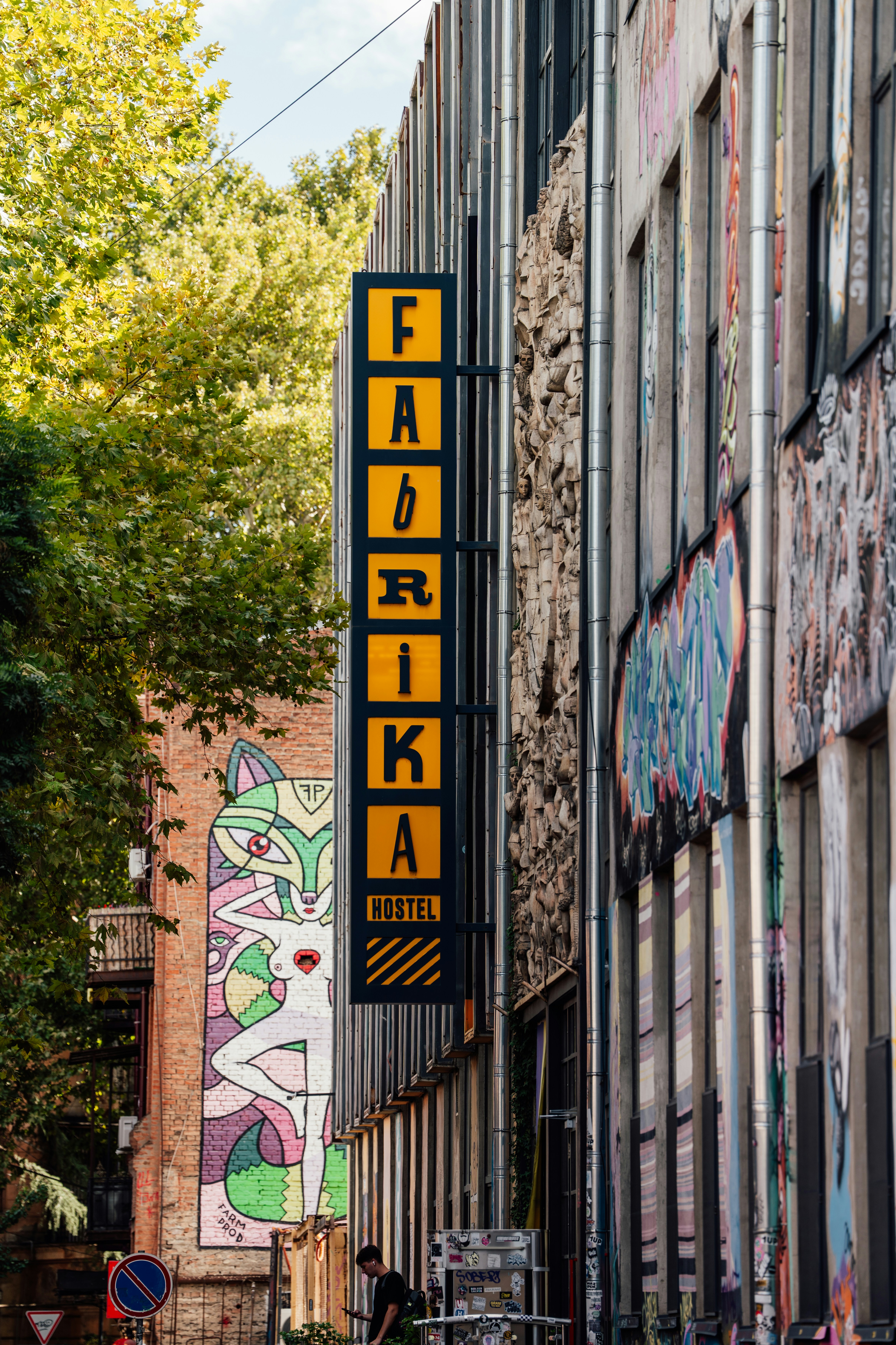 Cartello dell'ostello Fabrika con graffiti sull'edificio