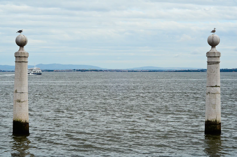 Two stone pillars in the water with seagulls