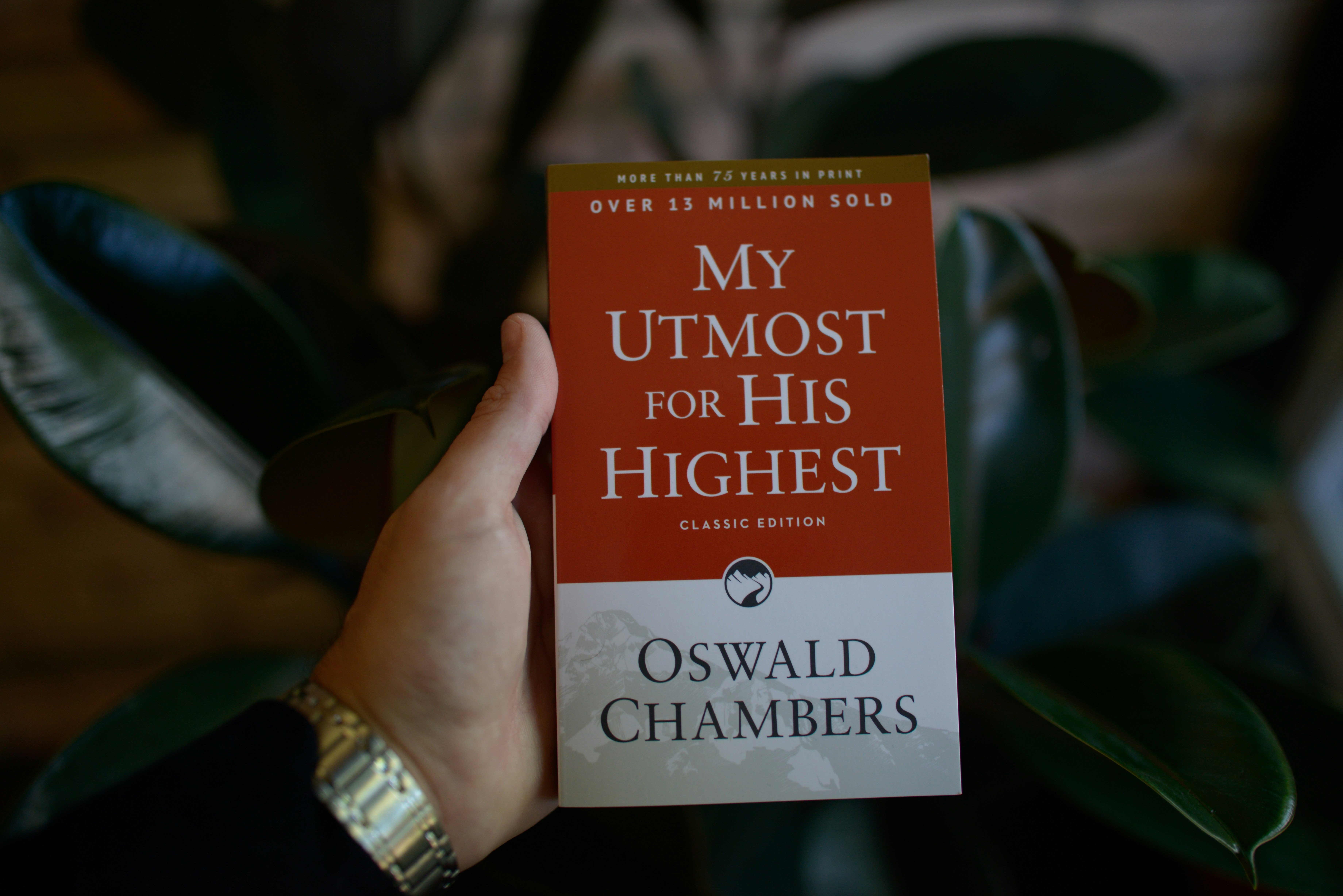 Hand holding "my utmost for his highest" book