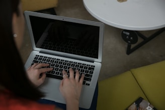 Woman typing on a laptop computer at a table