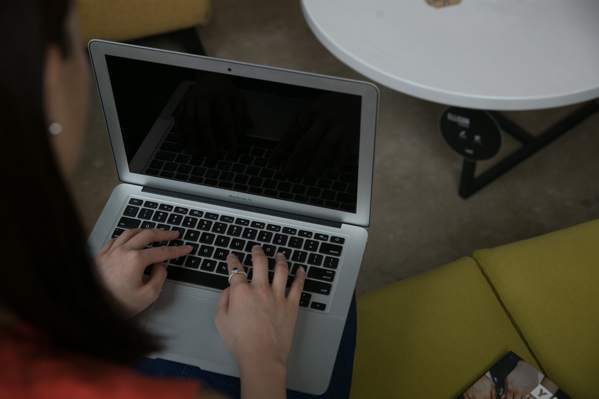 Woman typing on a laptop computer at a table
