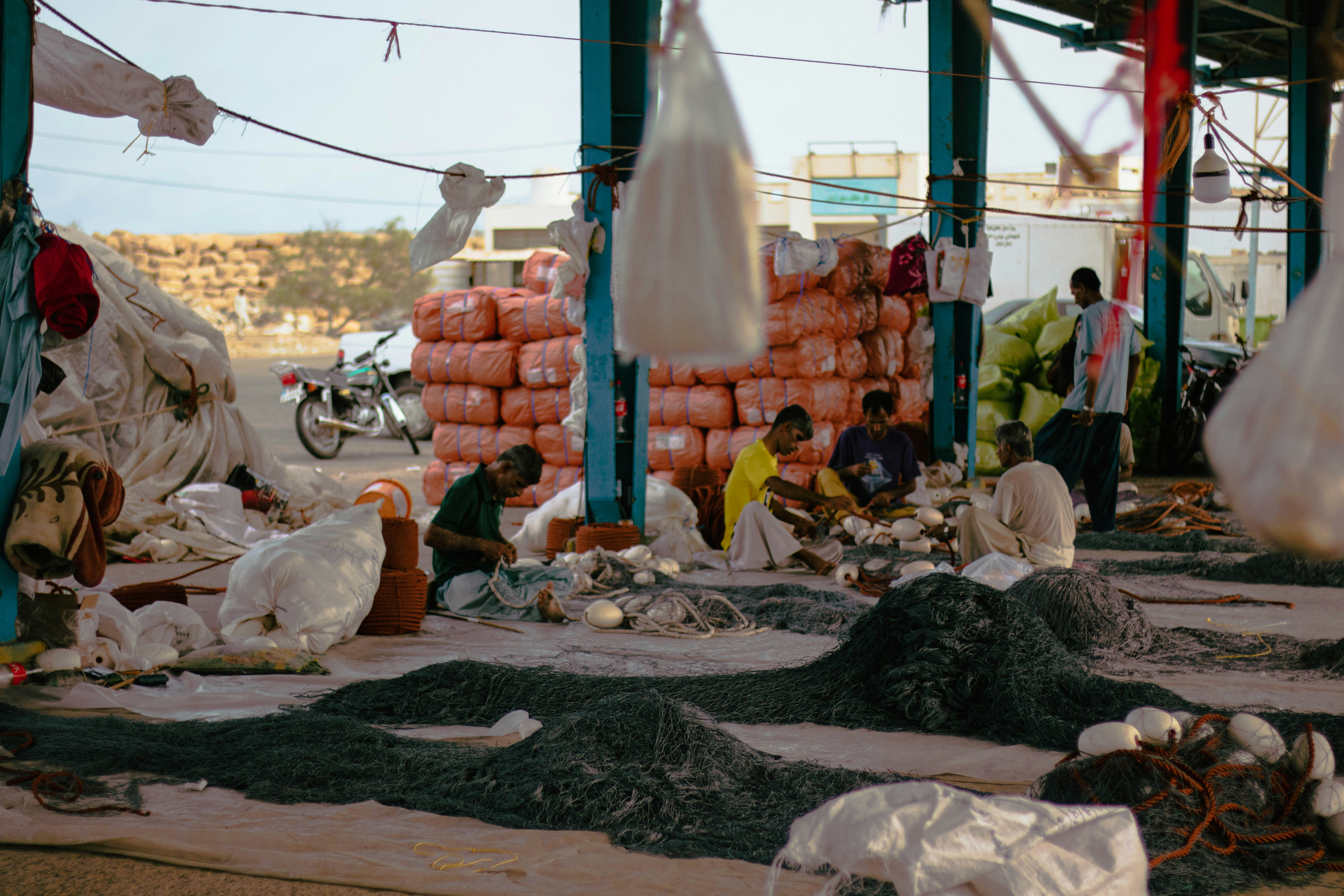 People working at a fish market with nets and fish
