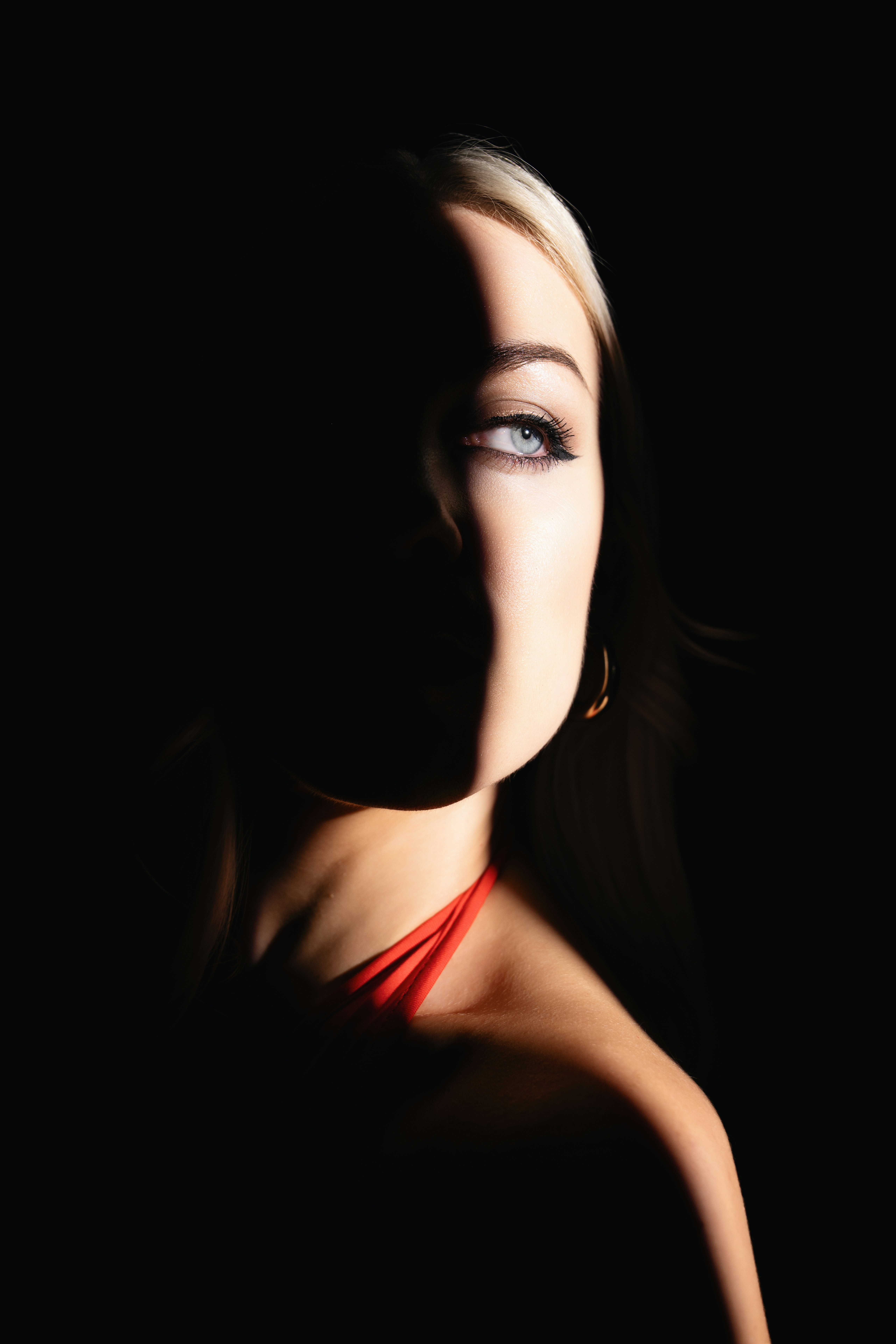 Viso della donna parzialmente illuminato su sfondo scuro