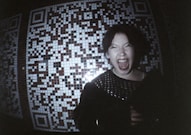 Woman screaming in front of qr code wall