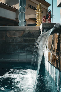Water flows over a stone fountain into pool.