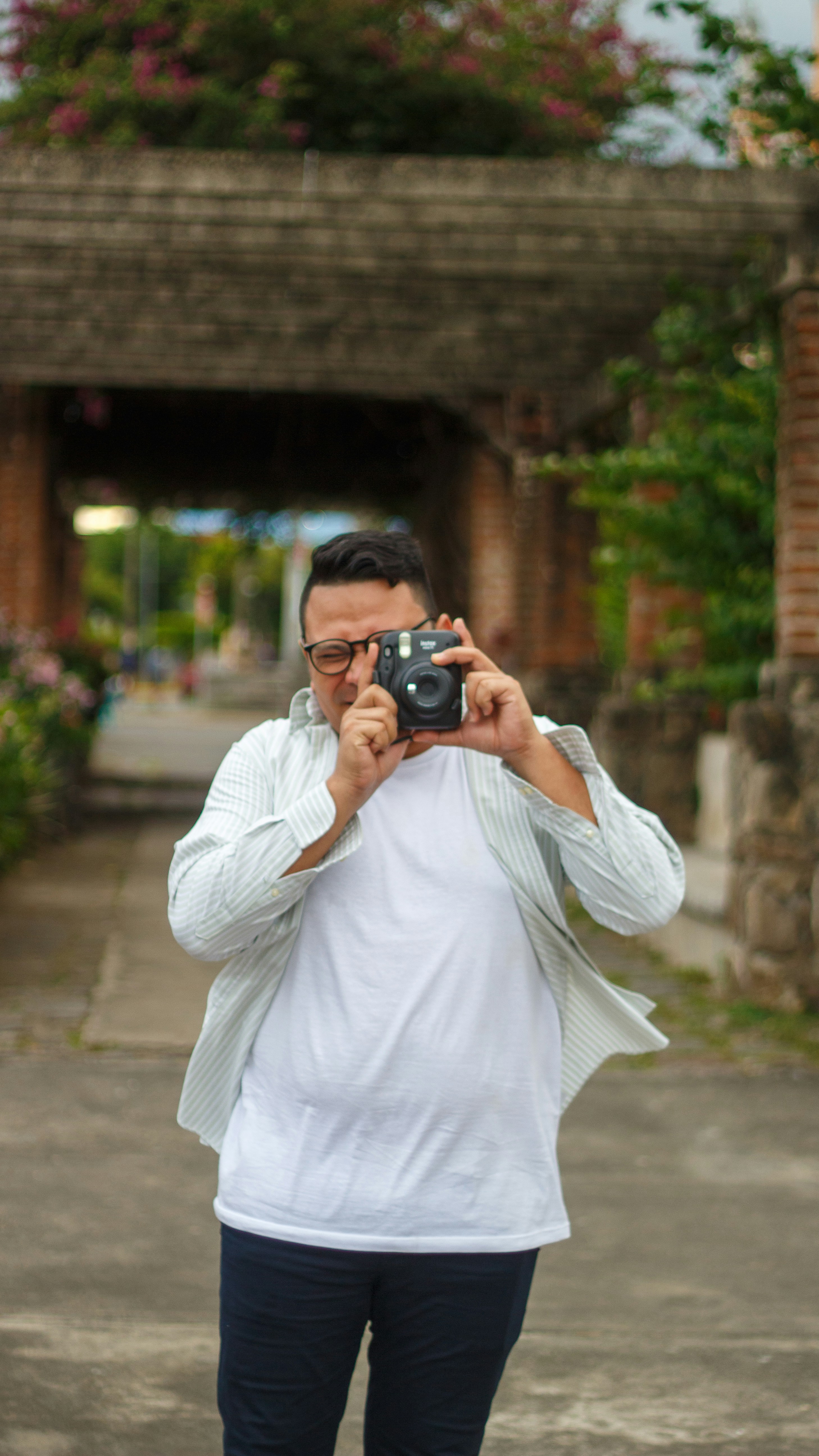 Man holding instant camera and taking a picture.