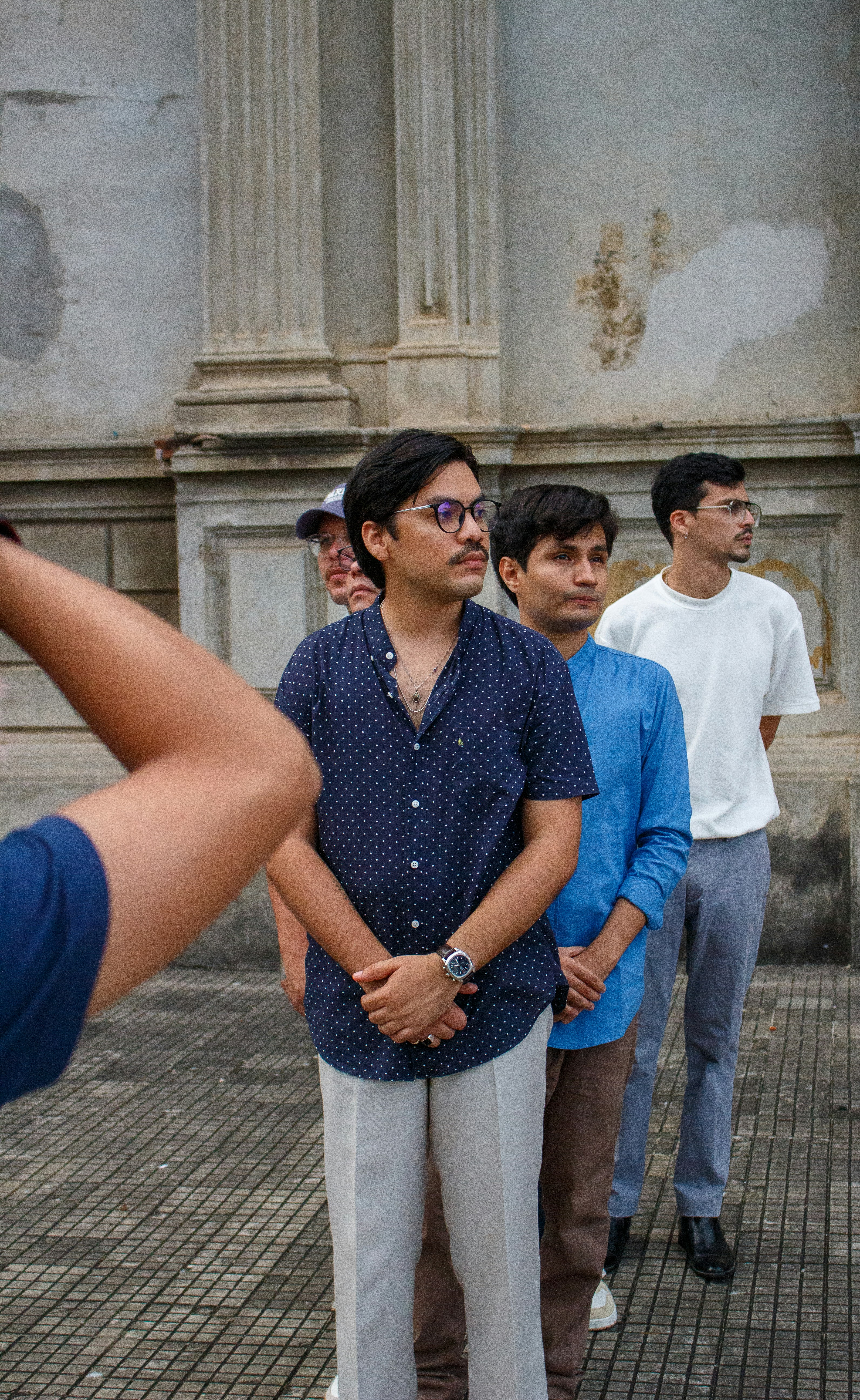 Cuatro hombres parados en una fila al aire libre