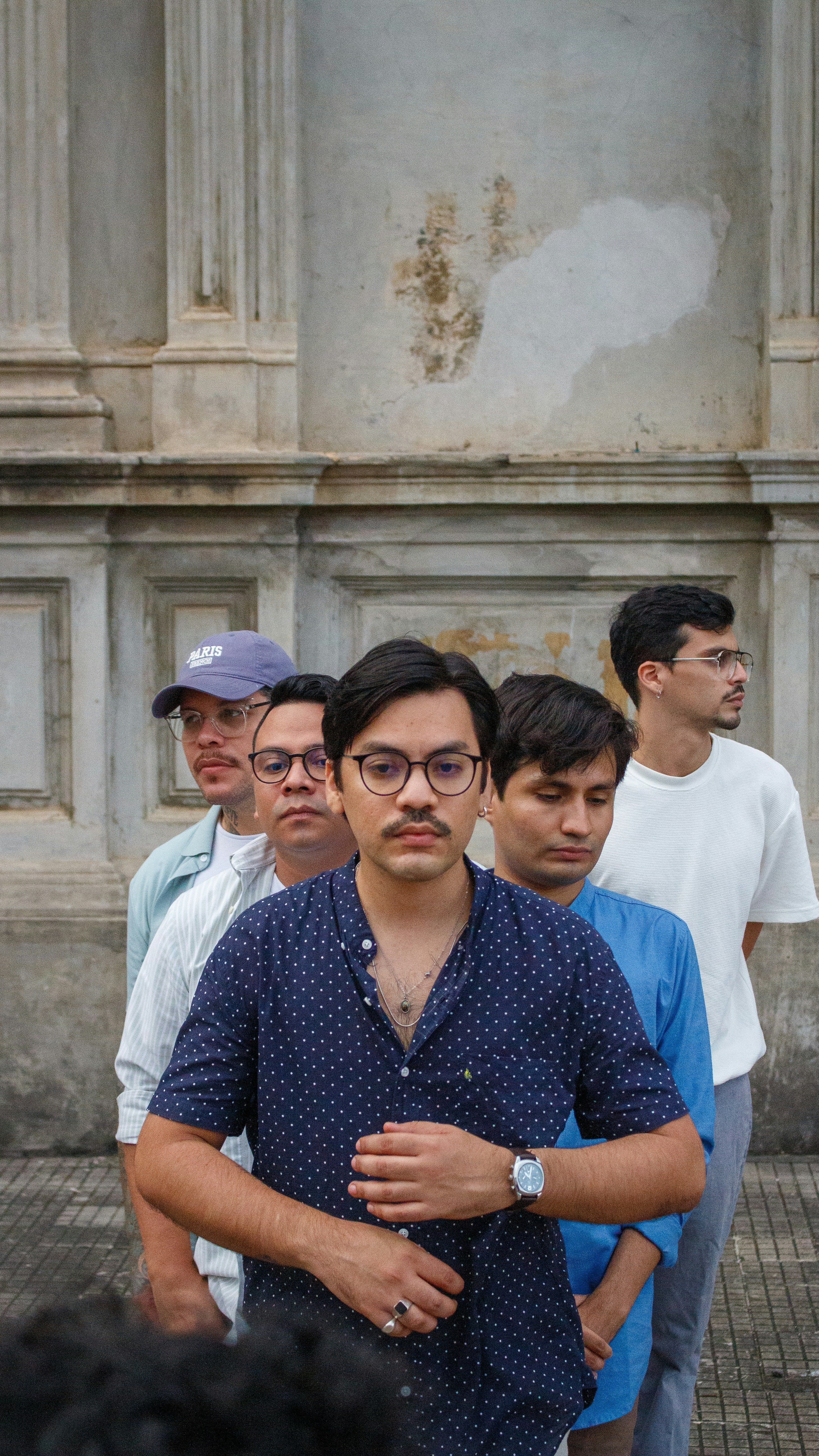 Five men standing in a line outdoors