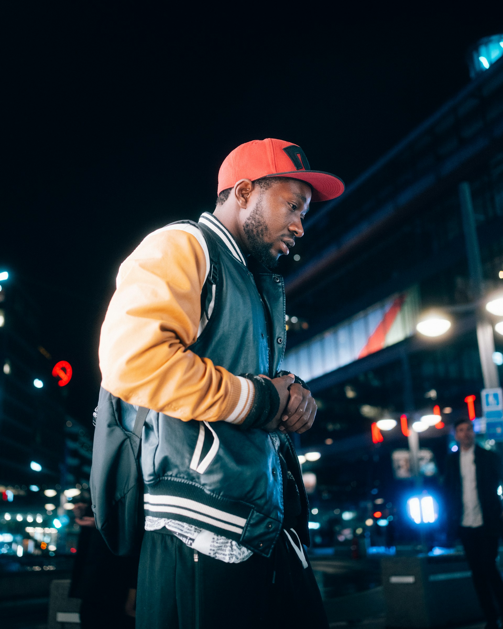 Man in a red cap walks at night