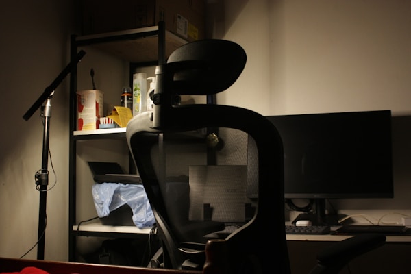 An office chair in front of a computer monitor.