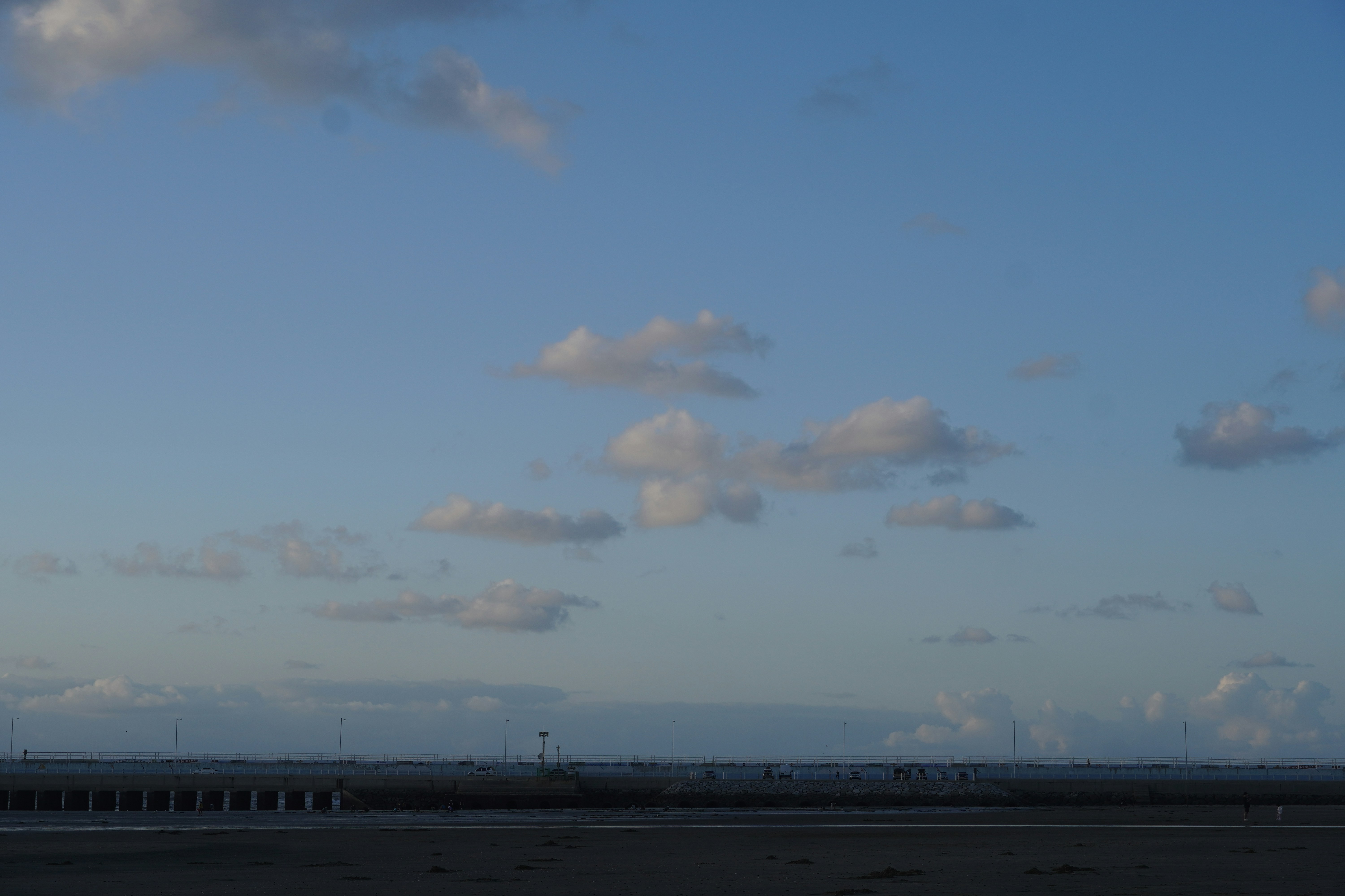 Scattered clouds drift across a clear blue sky.