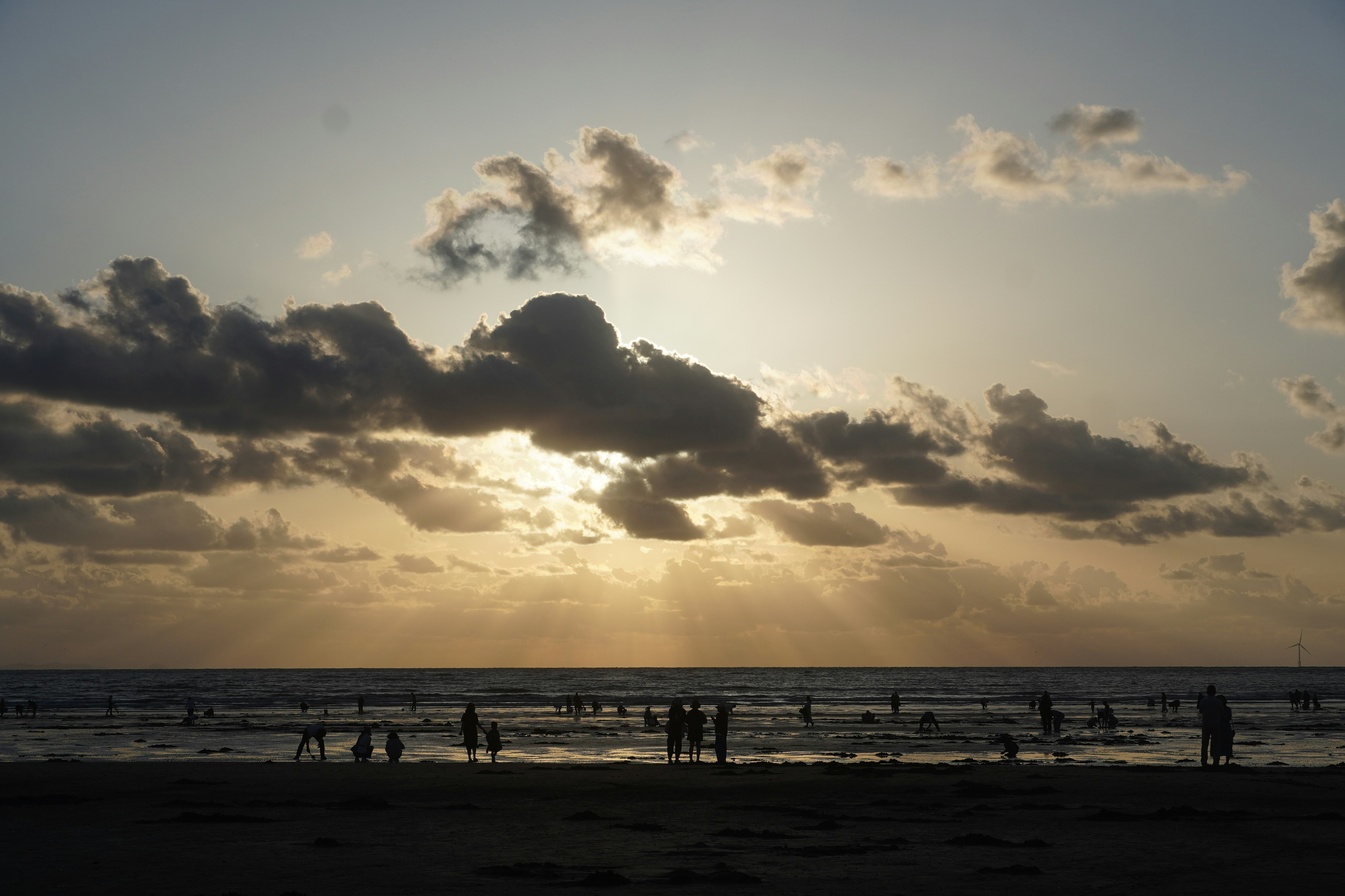 Sunset over a crowded beach with dramatic clouds