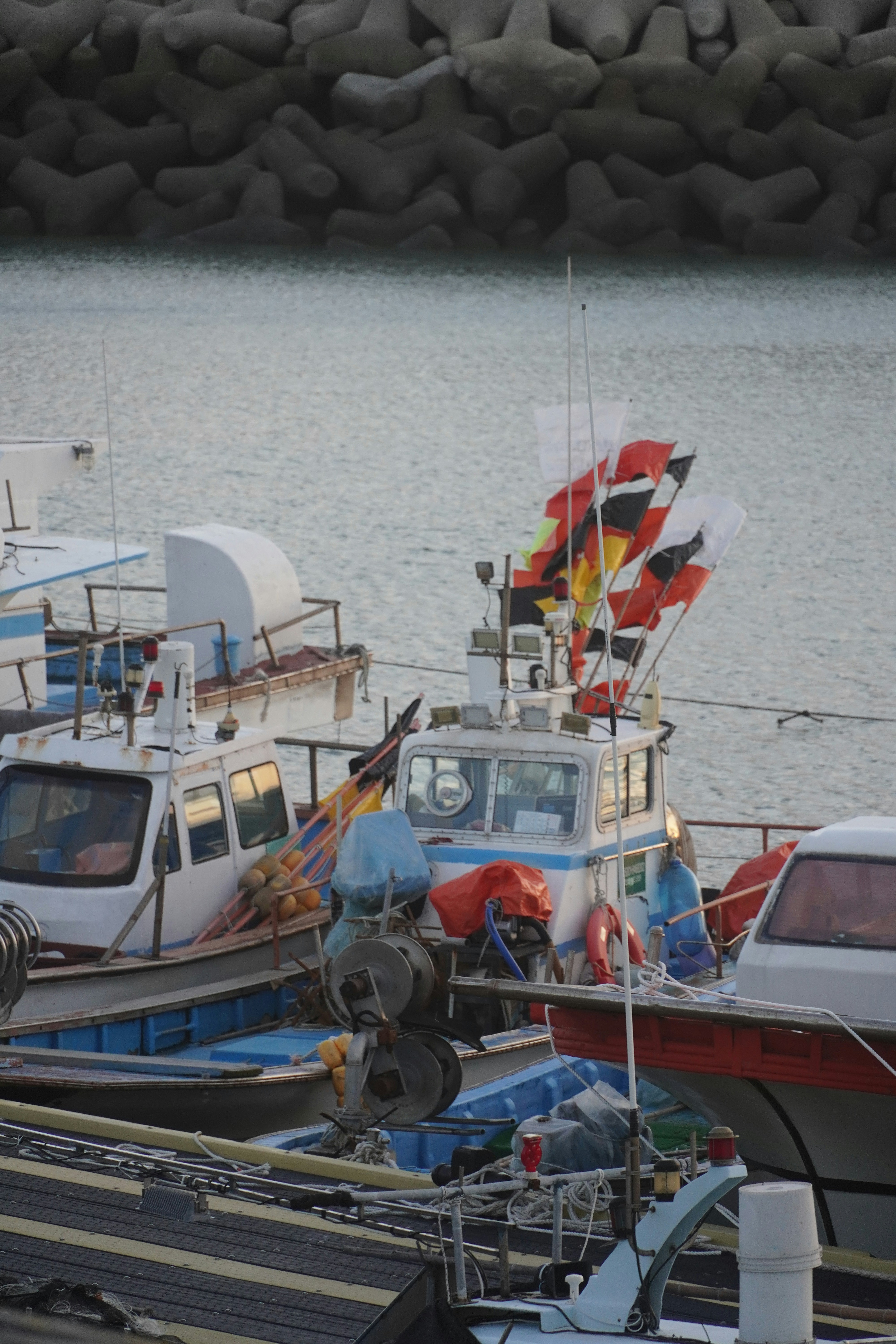Fishing boats with colorful flags docked at harbor
