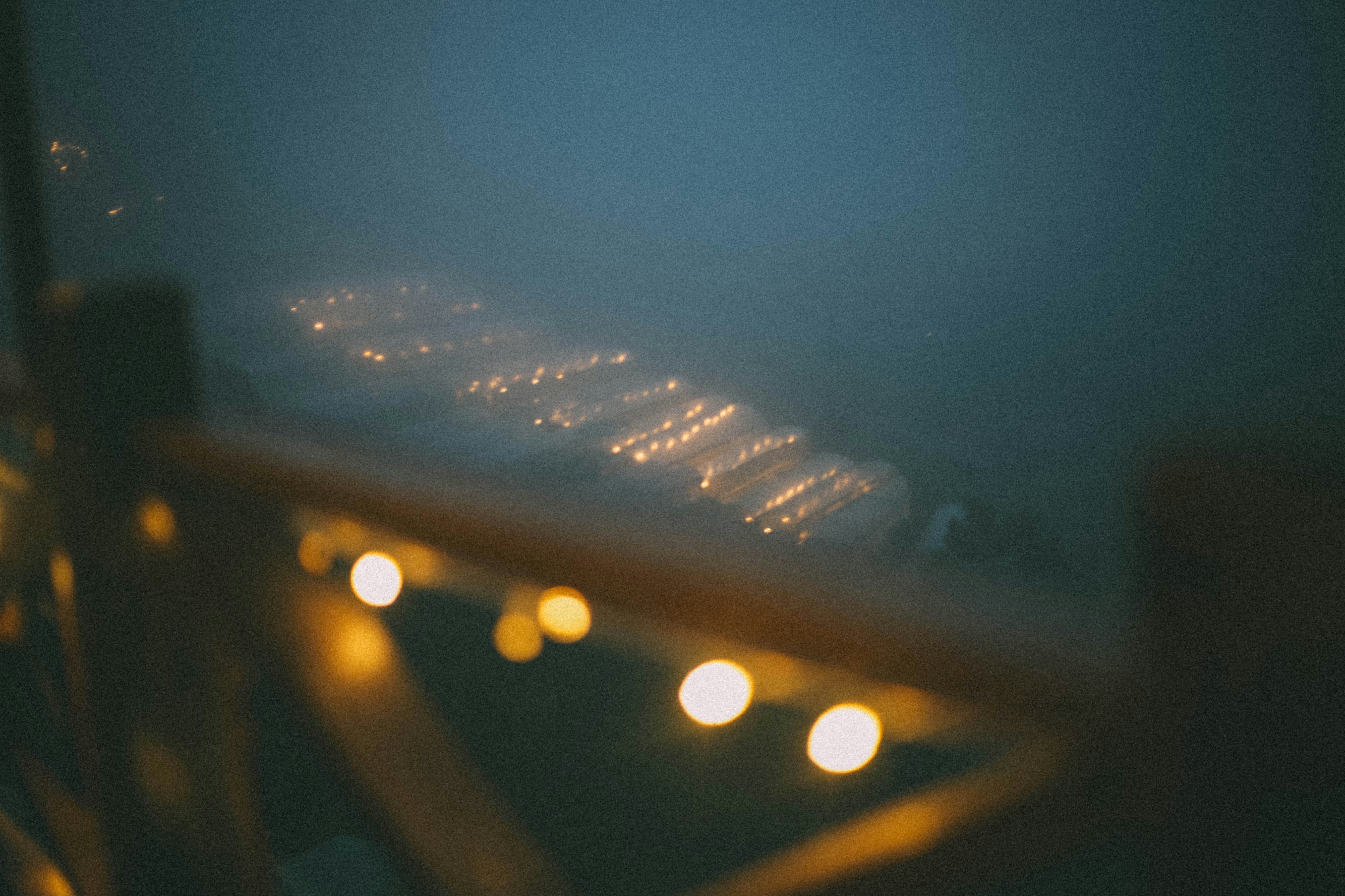 Blurred string lights over a misty water surface
