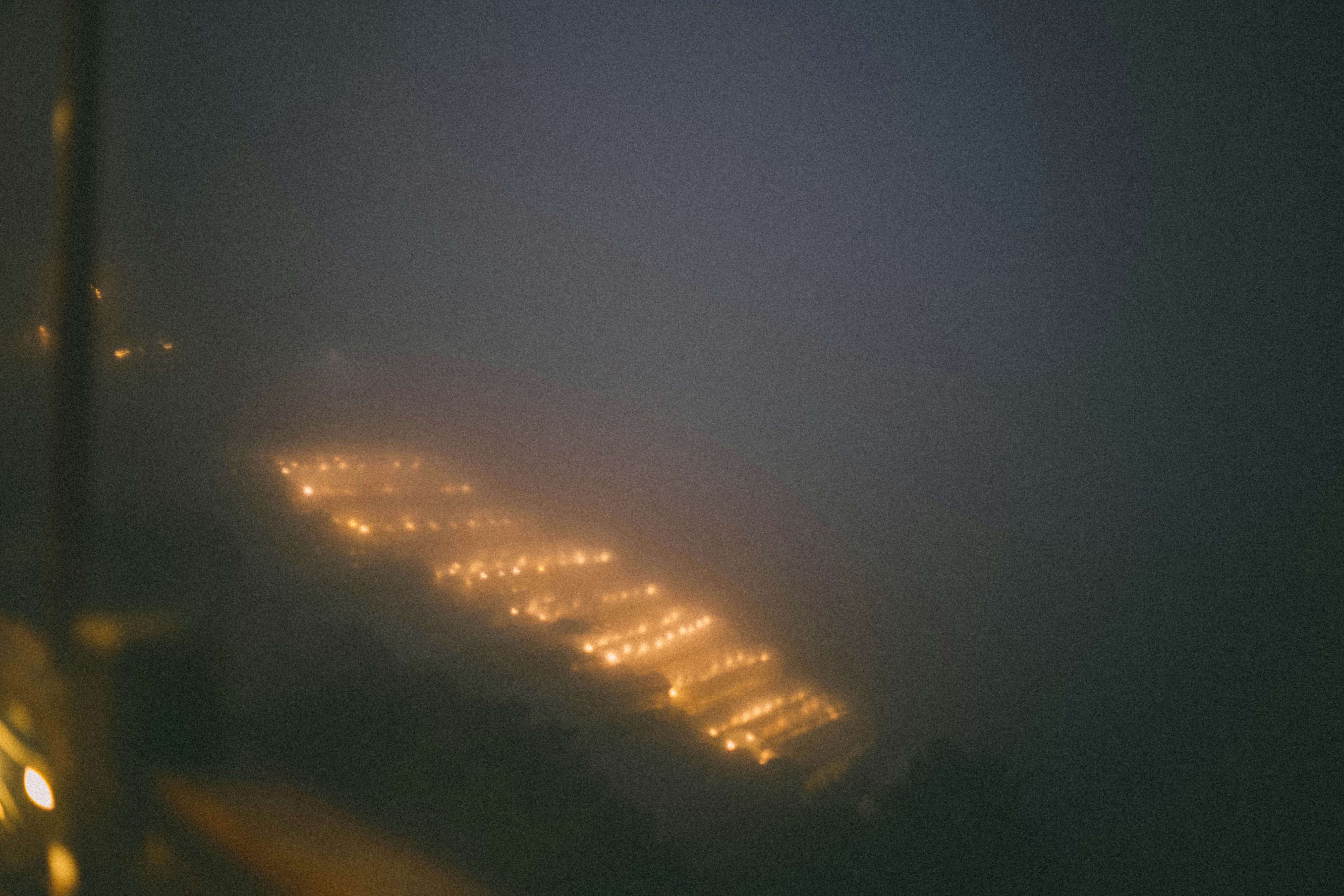Glowing lights on a foggy night path