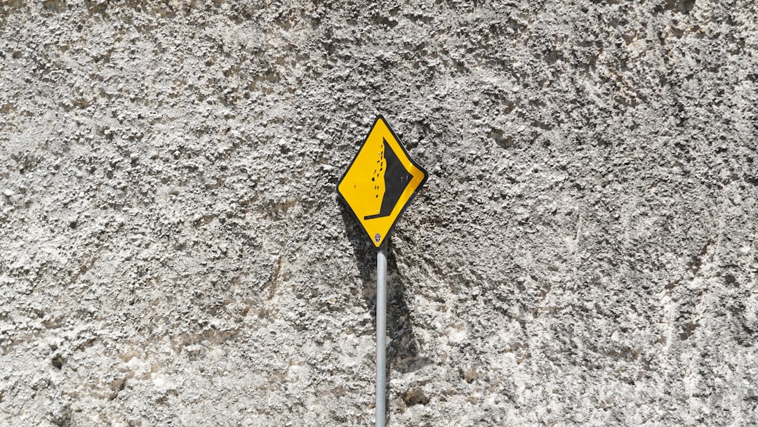 Yellow diamond sign against a textured wall