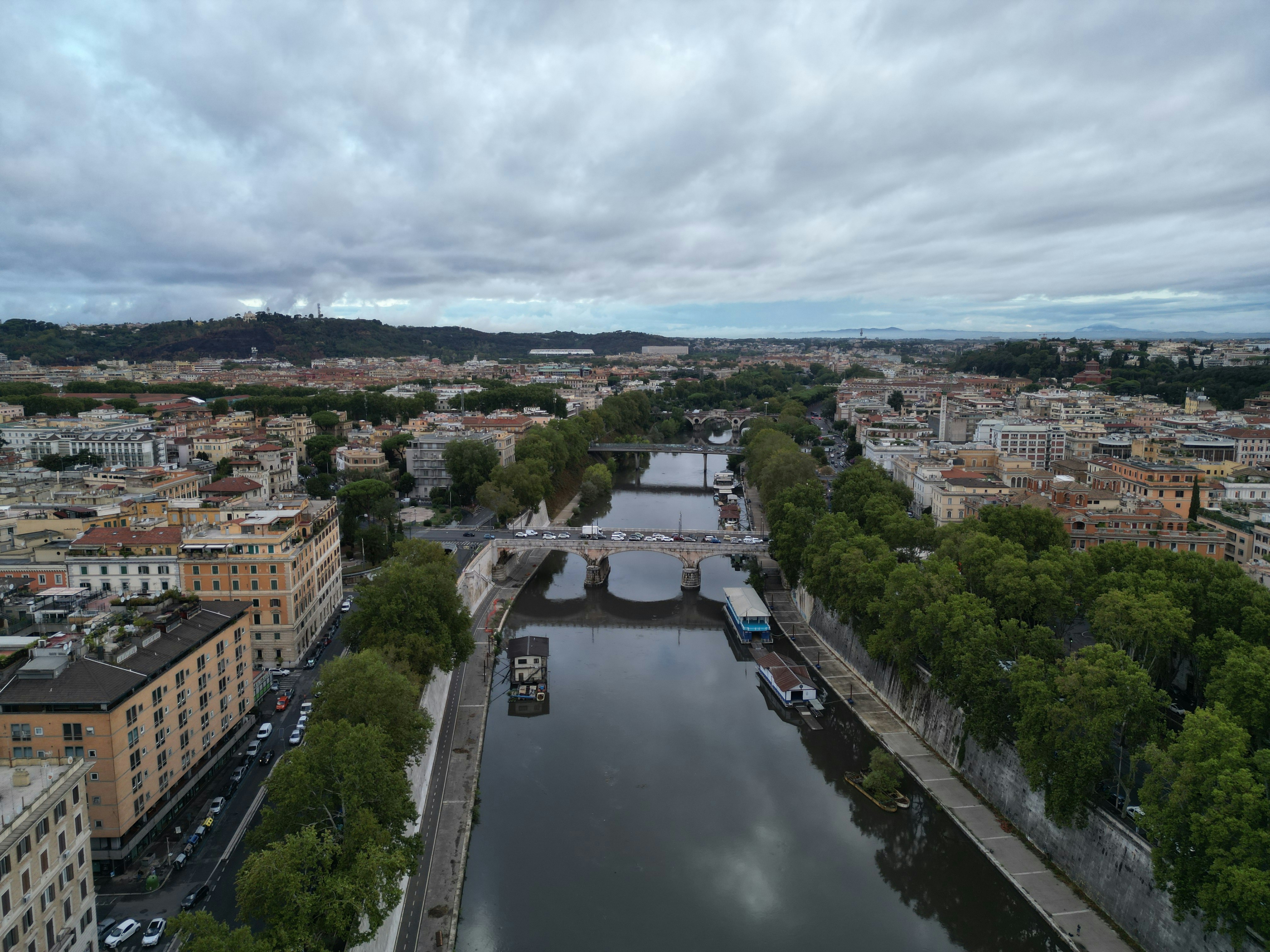 Cityscape with a wide river and bridges under cloudy sky