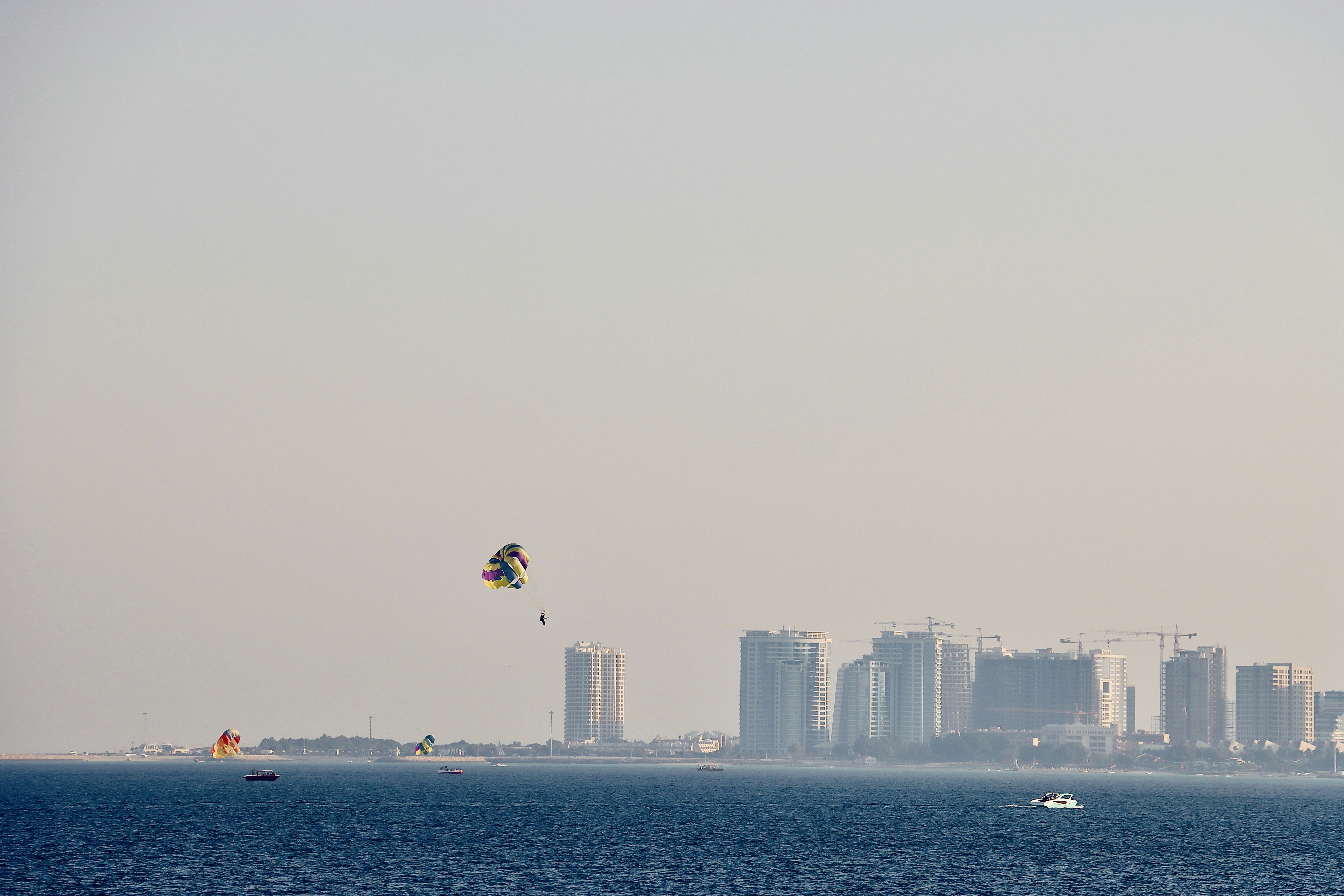 Parasailing over the ocean with city skyline background
