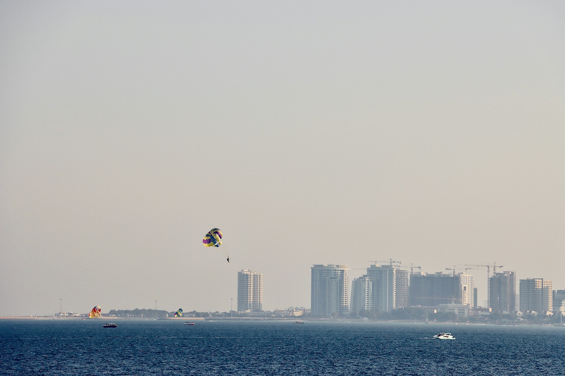 Parasailing over the ocean with city skyline background